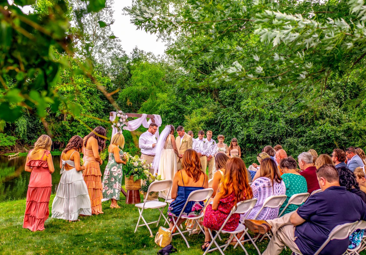 Large group of people in colorful attire seated outdoors for an event.