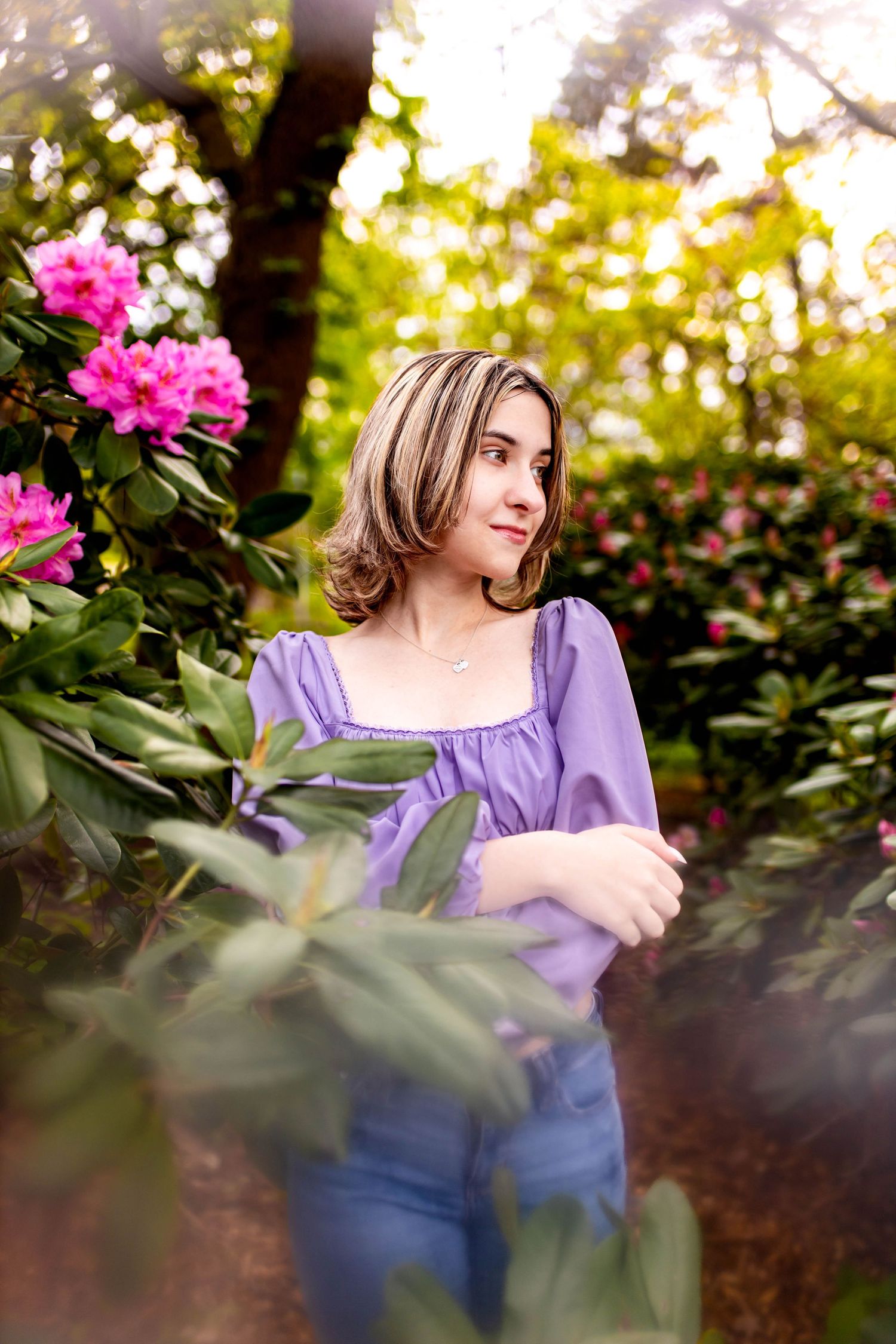 Portrait among pink rhododendron flowers in spring garden setting.