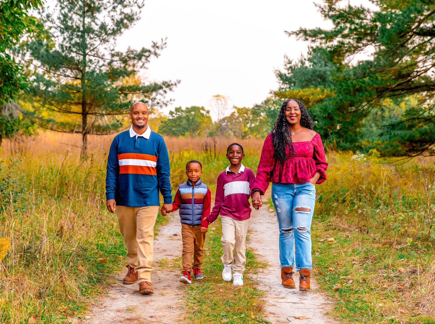 Family walking together on a nature trail during sunset with warm lighting.