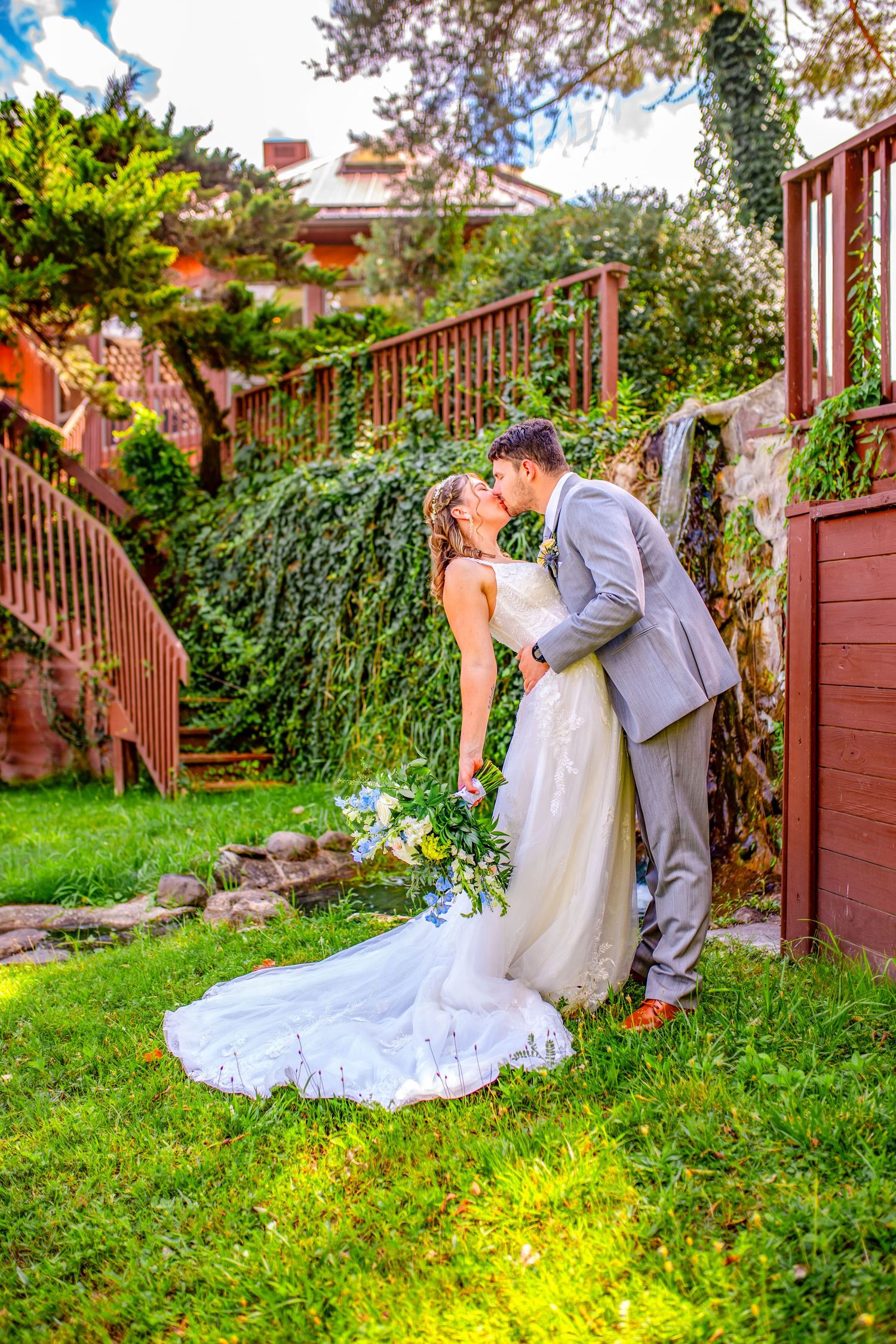 Wedding scene in garden setting with flowing white dress against green backdrop.