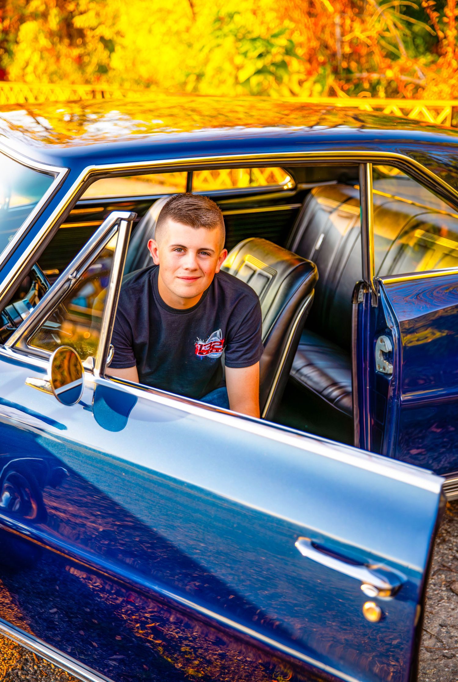 Vintage blue car photographed during golden hour with dramatic lighting.