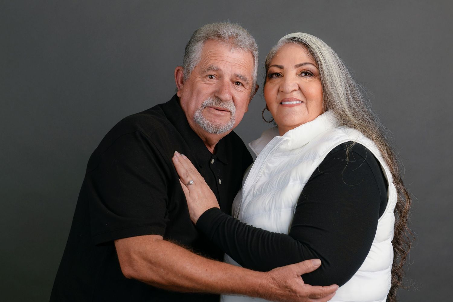 A series of six black and white photos showing a loving couple embracing and posing together against a dark background.