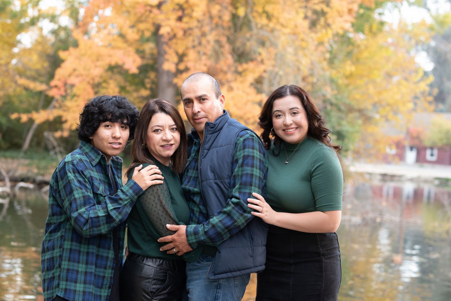 Group portrait series outdoors with autumn colors and water reflection in background.