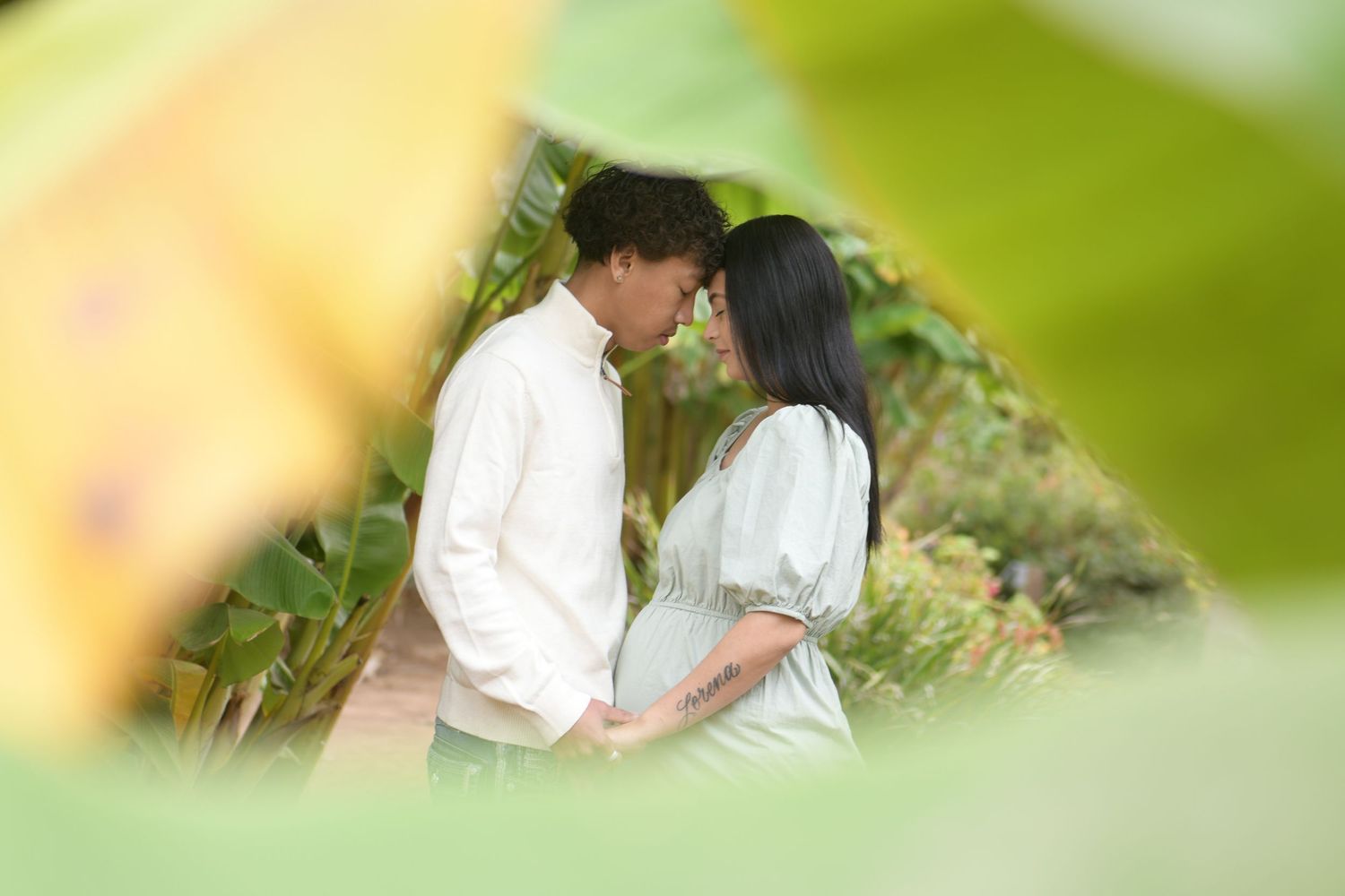 Soft green foliage creates a serene outdoor portrait backdrop in natural lighting.