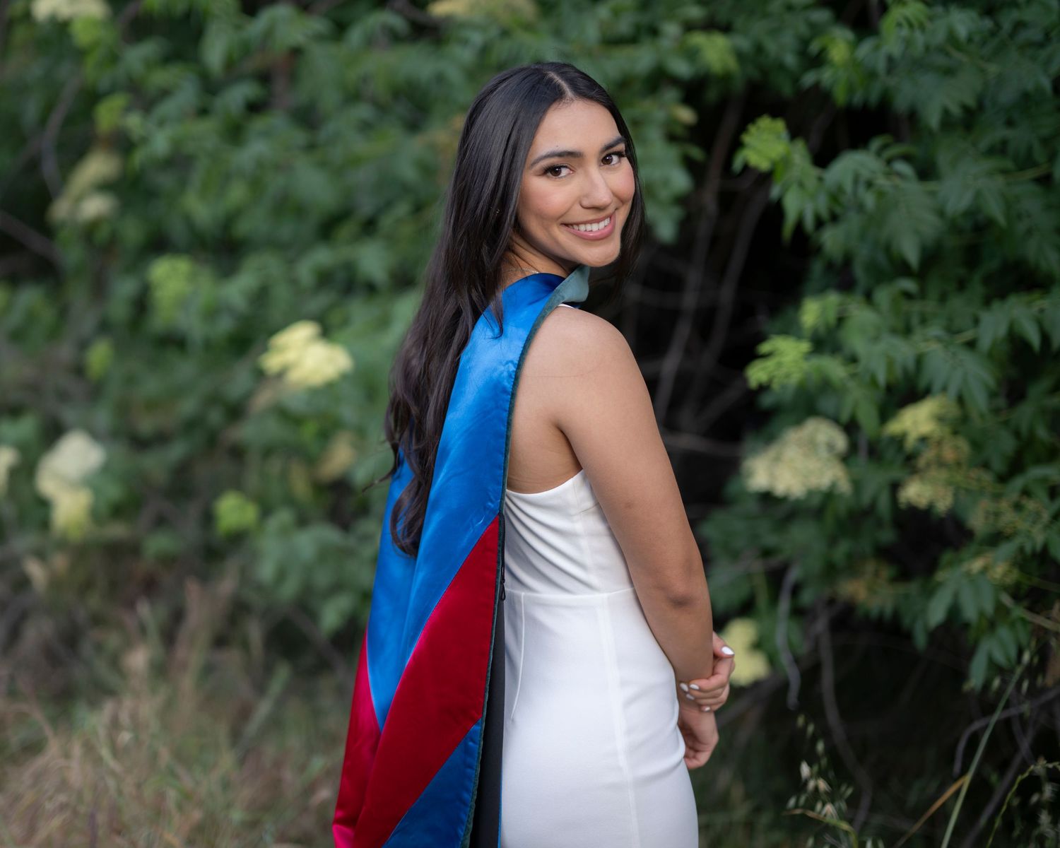 Outdoor portrait series with white dress against green foliage.