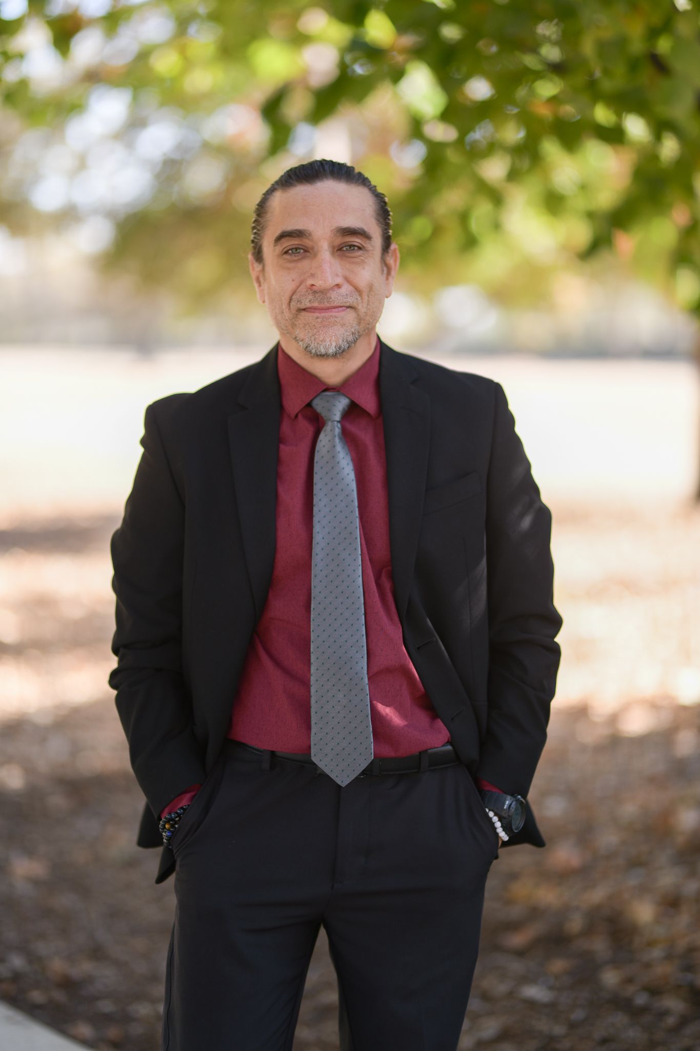 Professional portrait series of a person in business attire with burgundy tie against autumn backdrop.