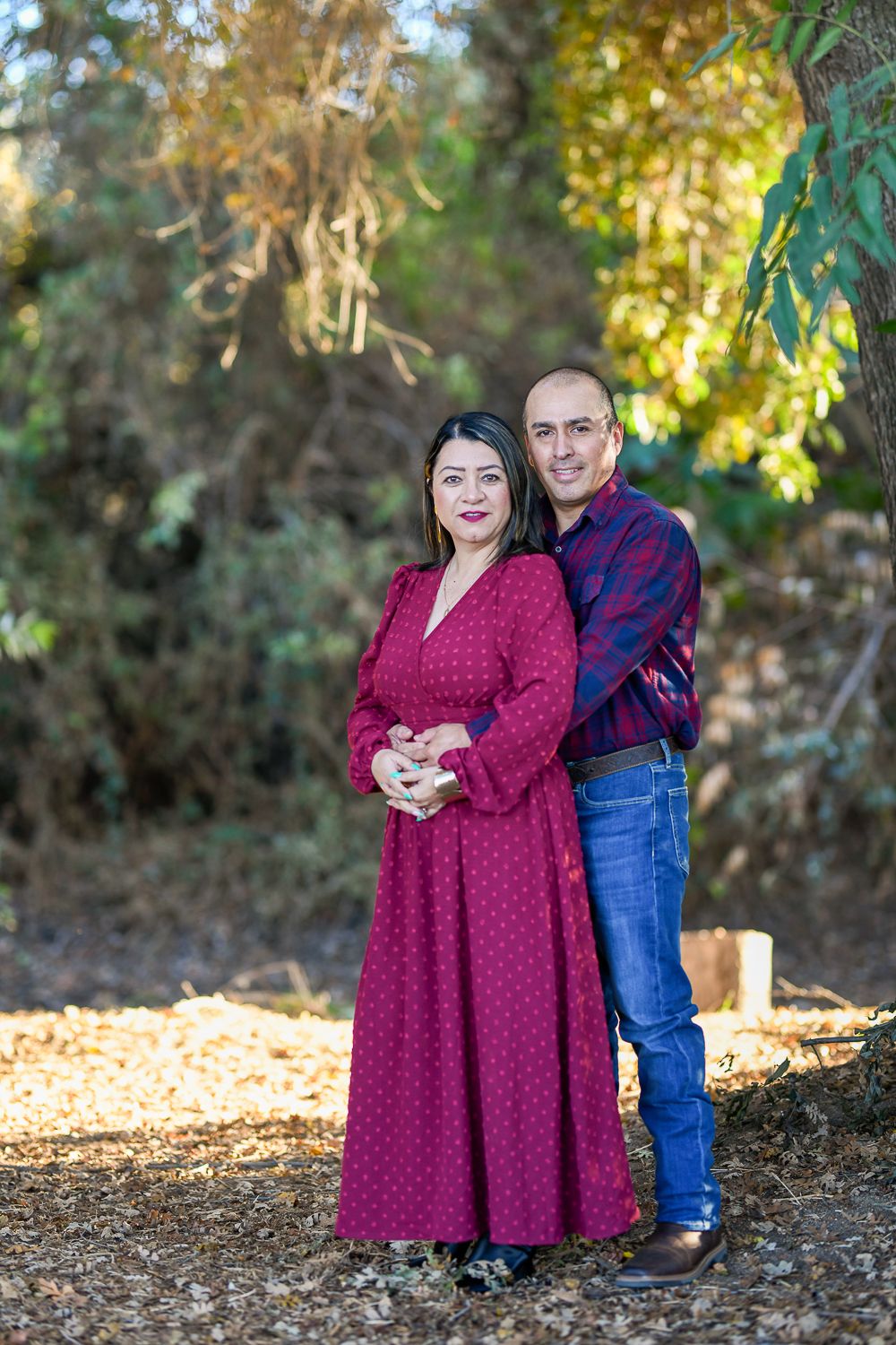 Series of romantic outdoor couple photos taken in a wooded setting with golden sunlight.