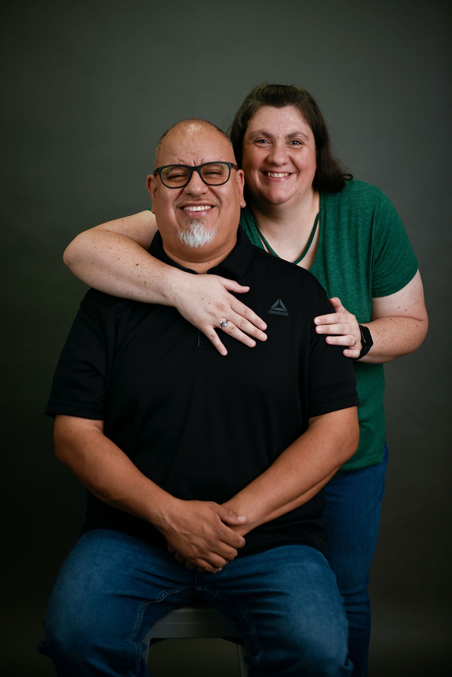 A series of four intimate portrait photos showing a couple in casual attire against a dark background.