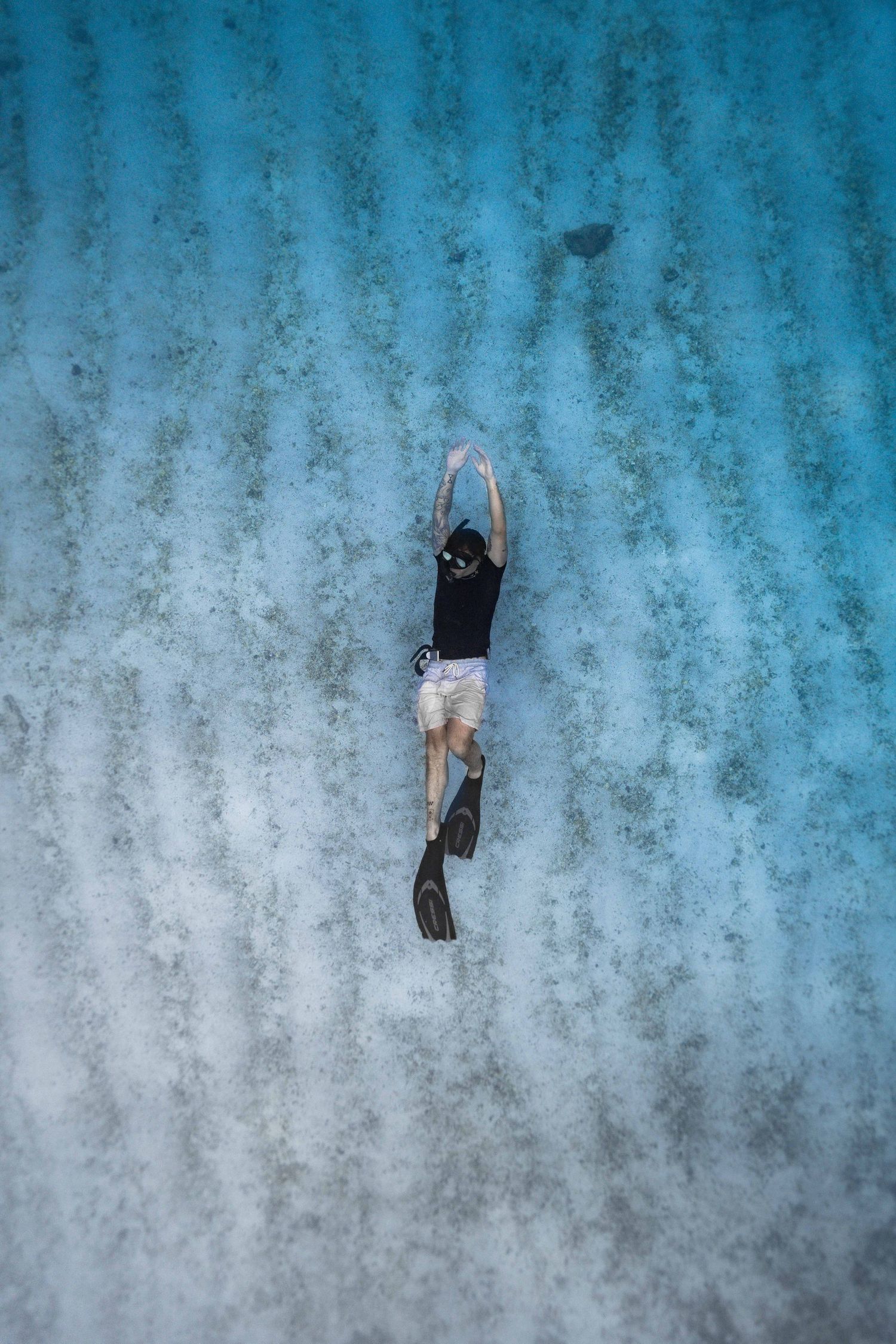 Split sequence of a diver descending against a blue underwater background.