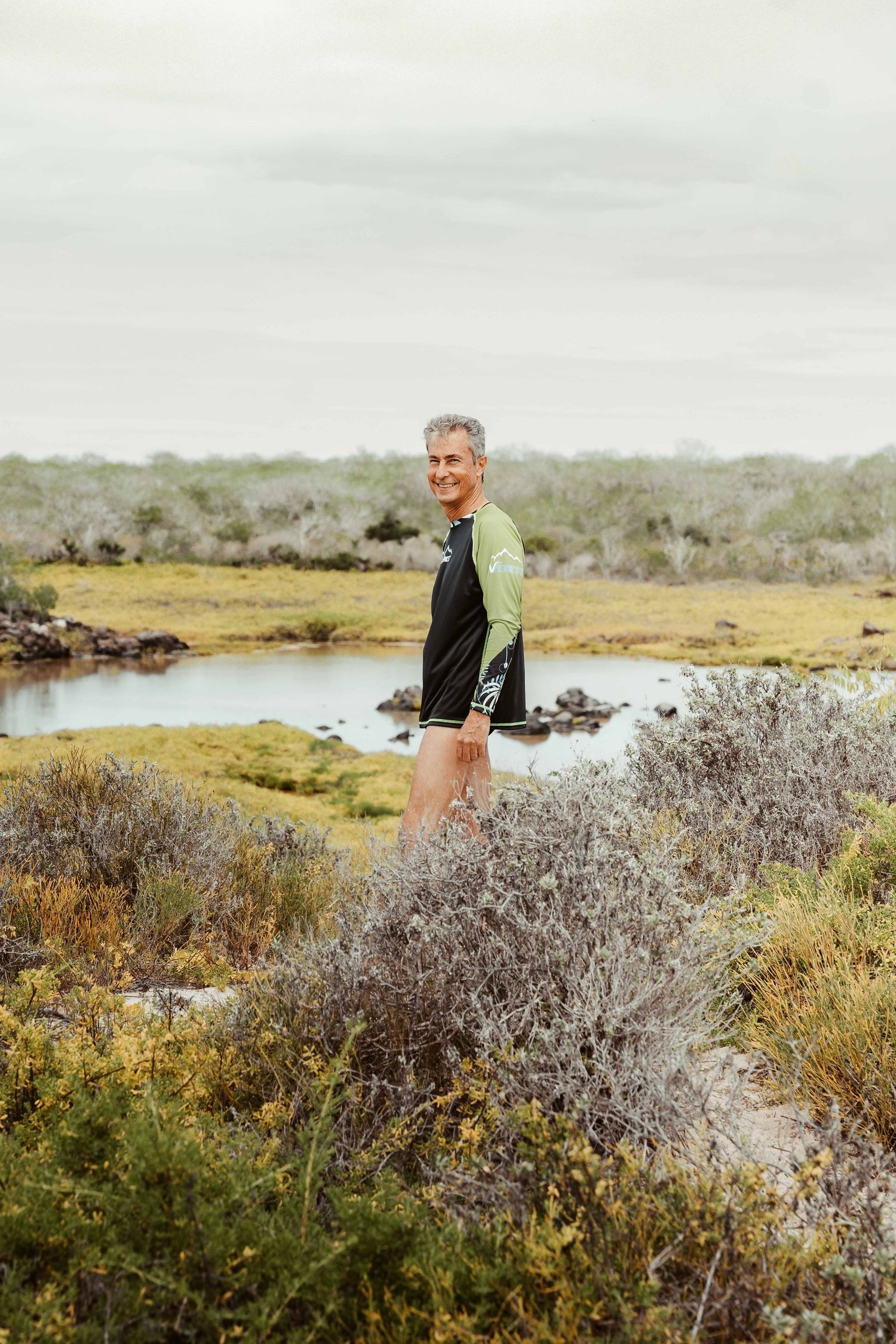 A photographer explores a scenic wetland landscape with marsh grasses and water features in natural lighting.