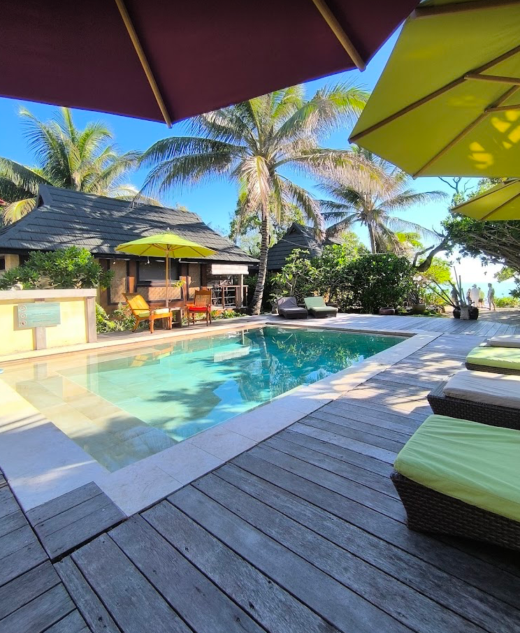 Luxurious poolside lounge area with yellow umbrellas and palm trees at a tropical resort showing multiple viewing angles.