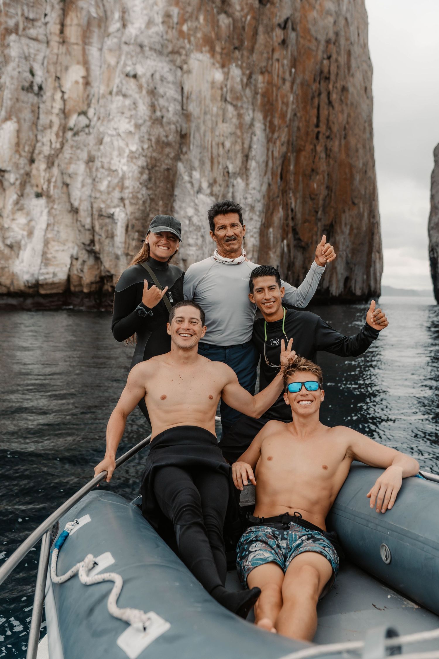 Group enjoying boat ride near dramatic coastal cliffs on ocean adventure.