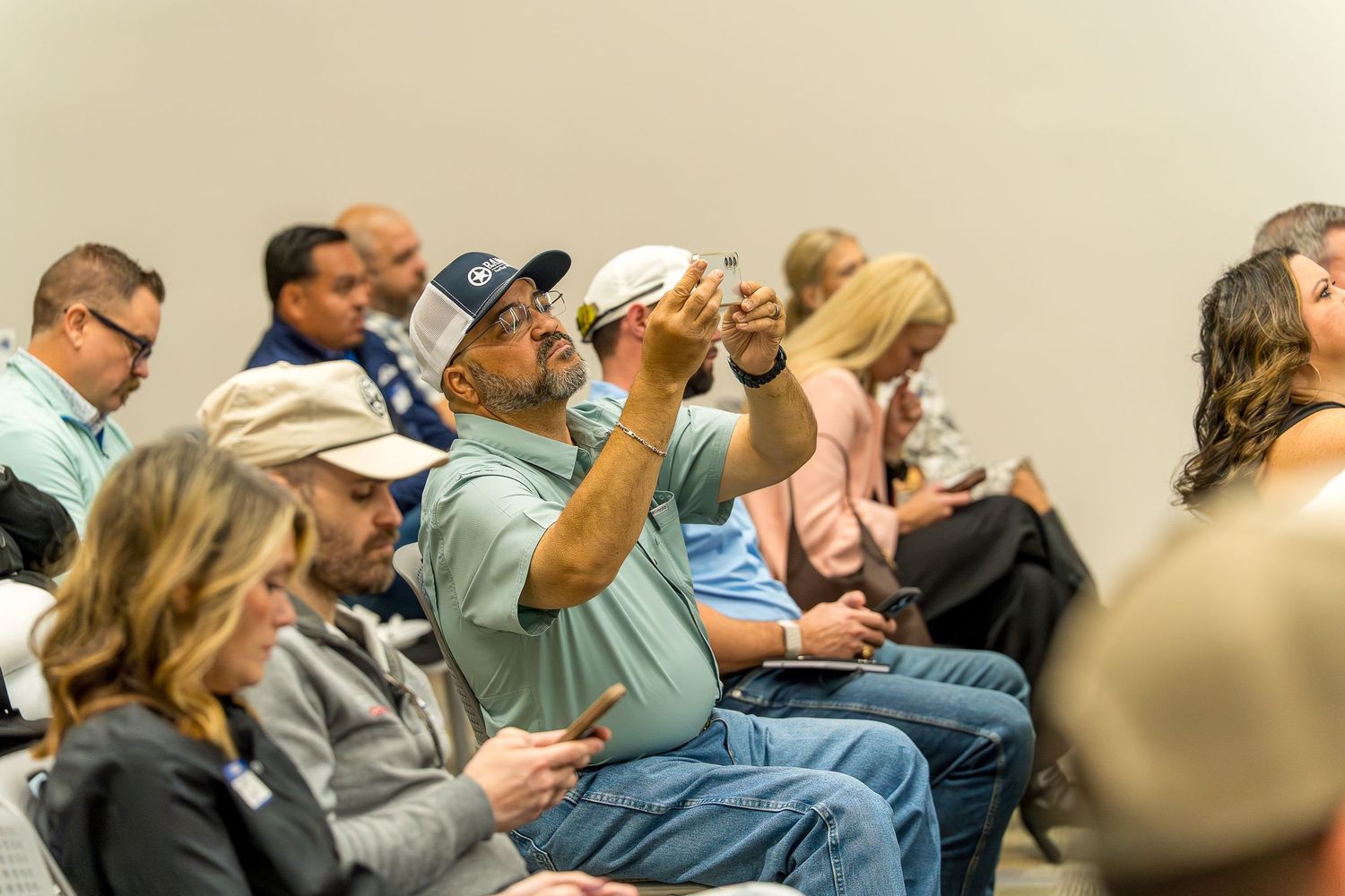 Audience members seated in rows at an indoor event.