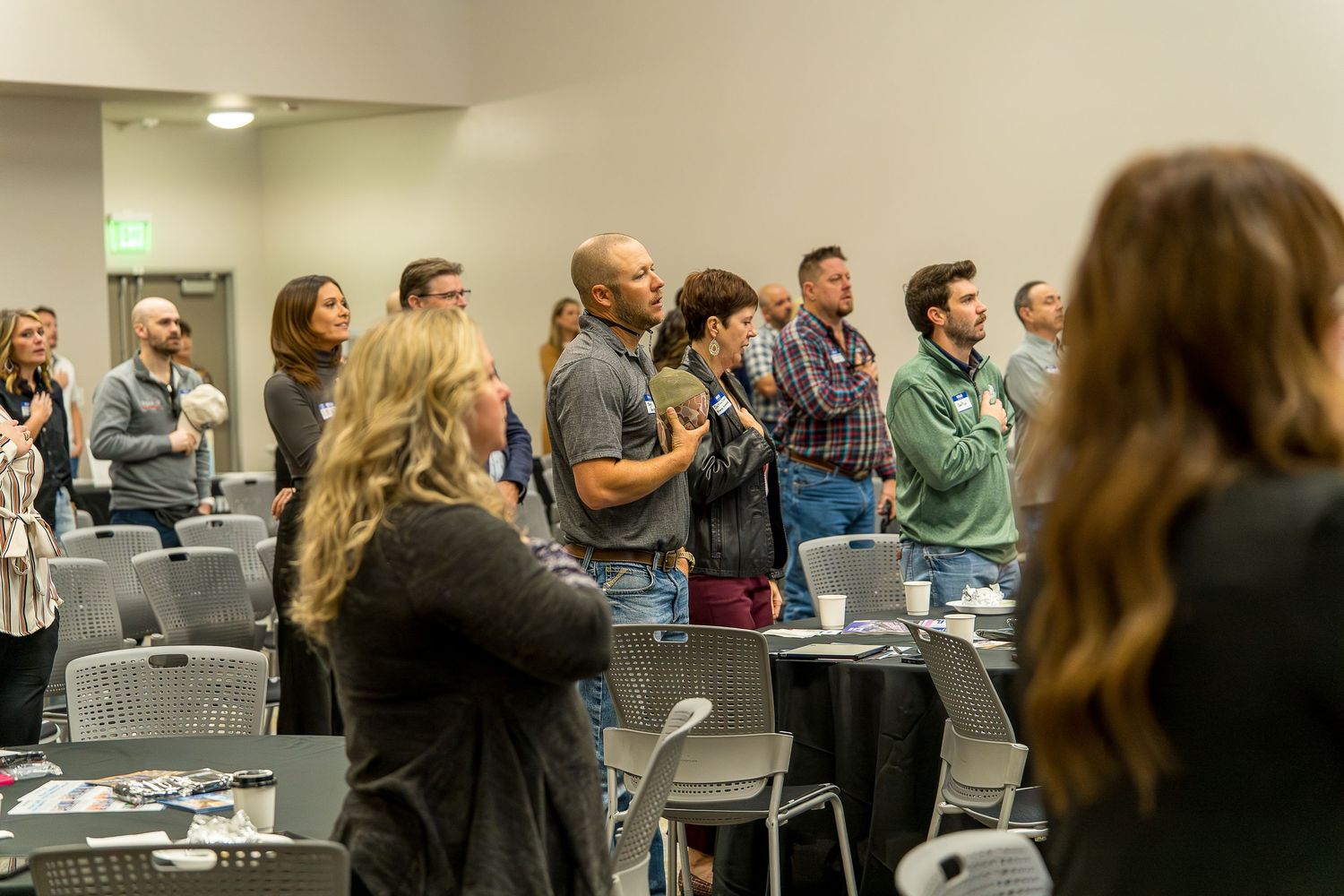 Group of attendees standing and applauding during a business presentation.