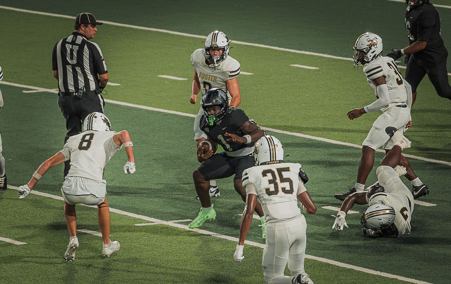 Football players in black and white jerseys line up during a game play.
