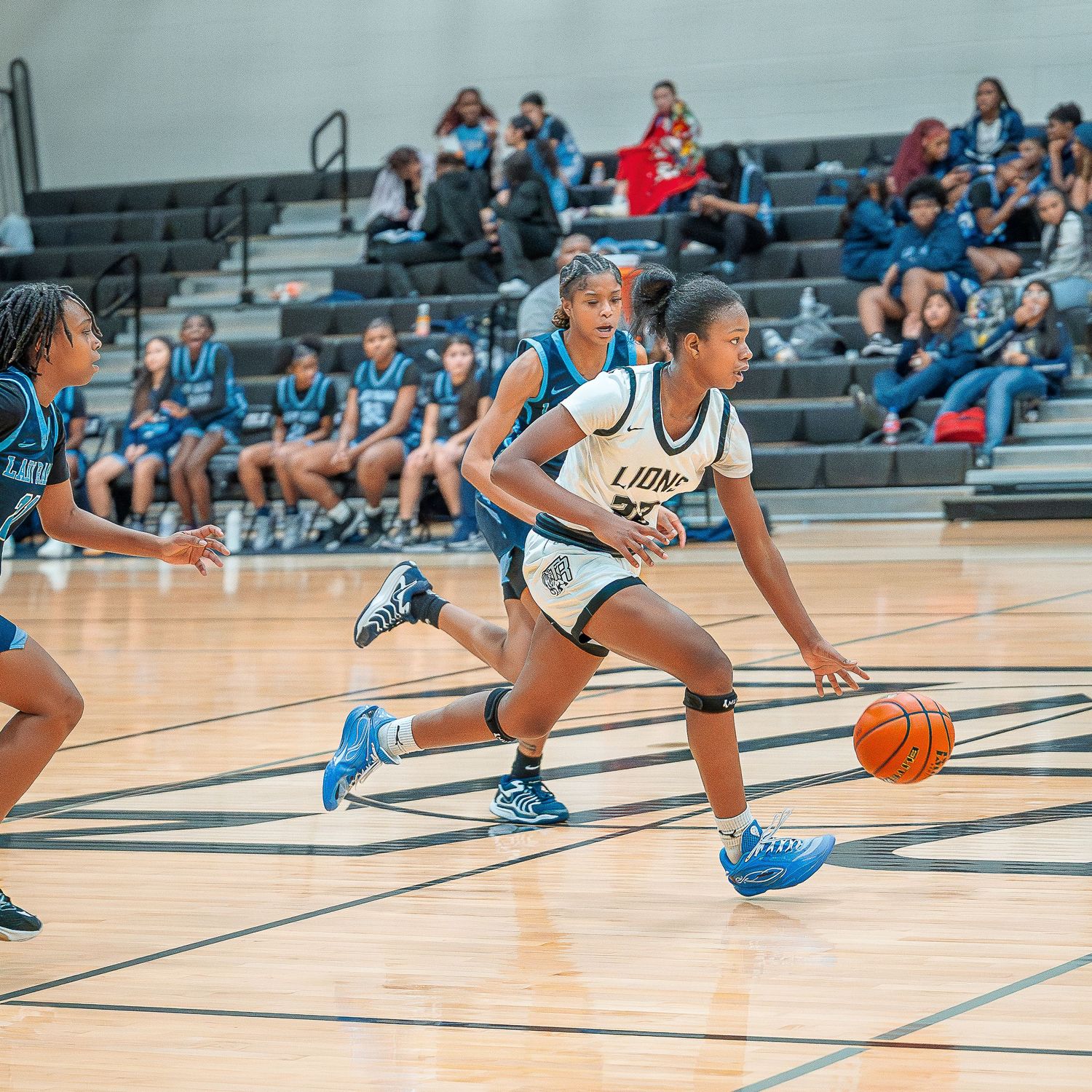 Basketball player dives for a loose ball on the court during an intense game sequence.