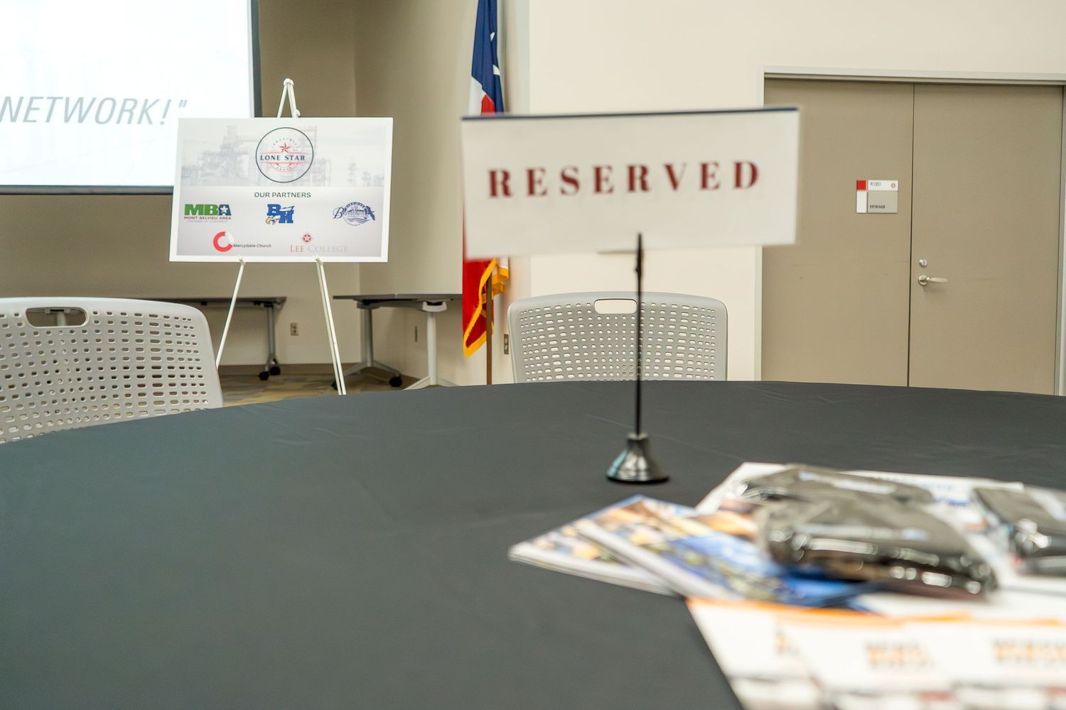 Conference room table with reserved signs and meeting materials set up.