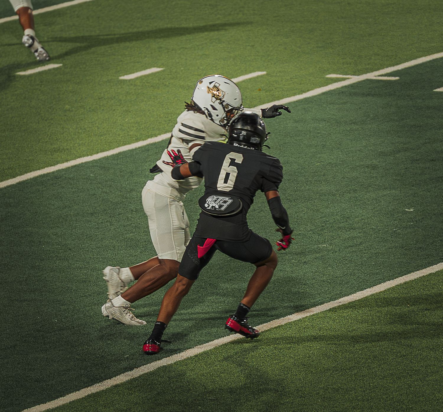 Football players in different colored uniforms compete for position during a play.