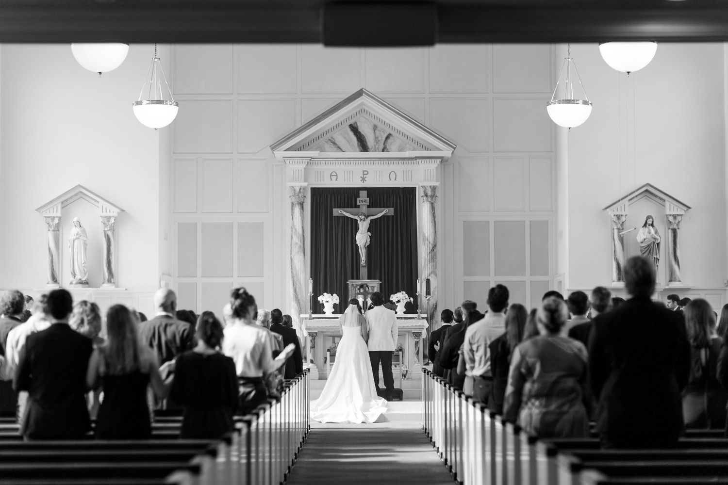 A traditional church wedding ceremony with guests watching the couple at the altar.