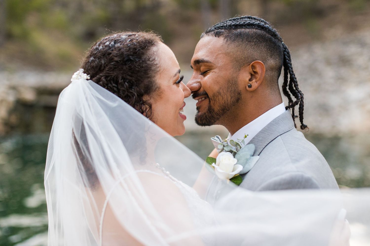 A wedding couple shares an intimate moment together while wearing traditional wedding attire.