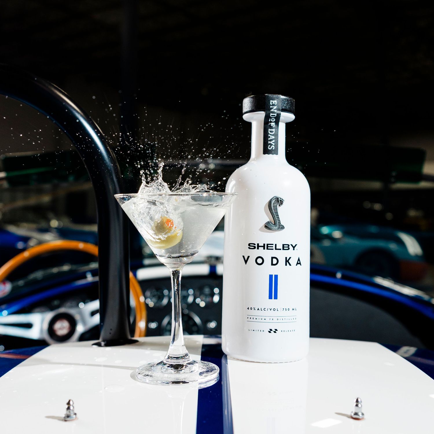Vodka cocktail splashing in martini glass with bottle display against dark background.