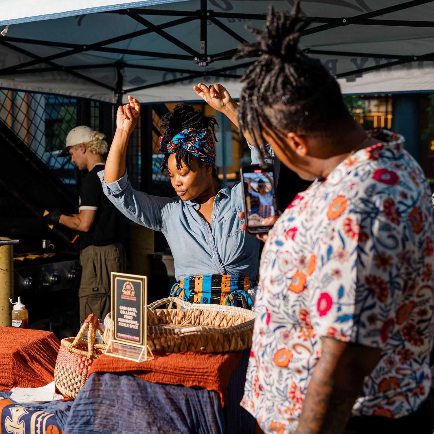 Vibrant market scene with vendor interacting at outdoor food stall.