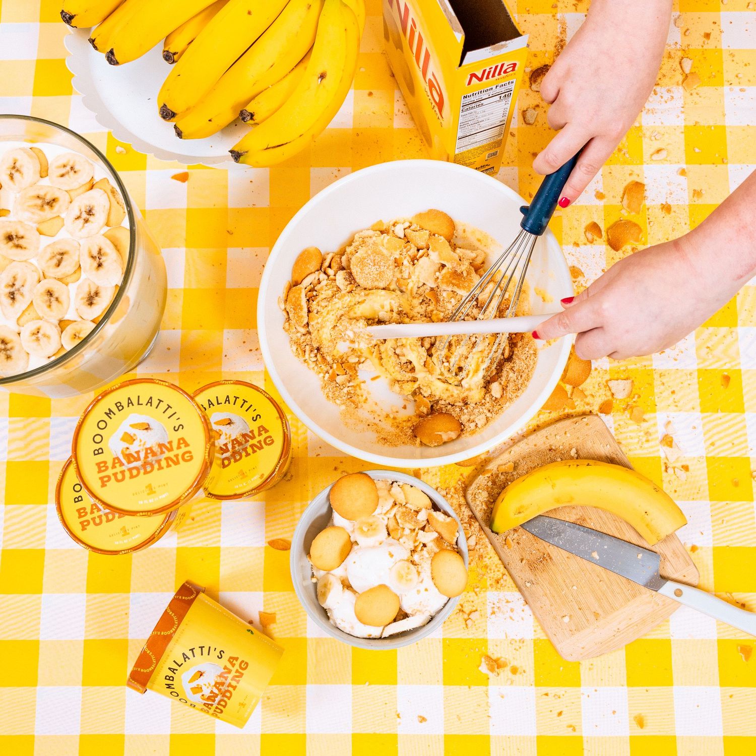 Yellow gingham tablecloth with bananas and pastries arranged for breakfast.