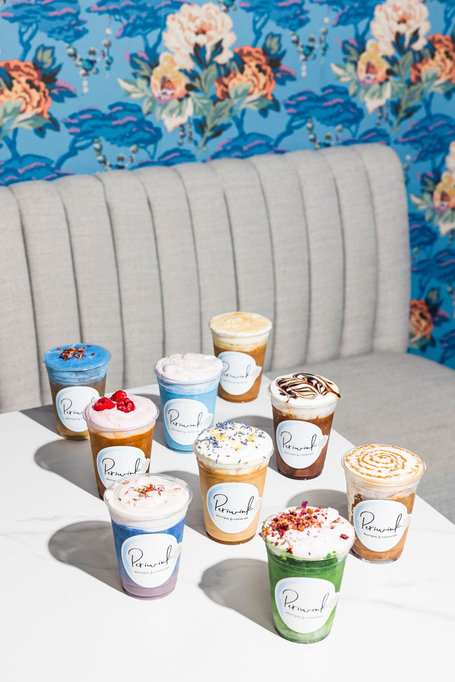 Colorful ice cream pints displayed on white counter against blue floral wallpaper.