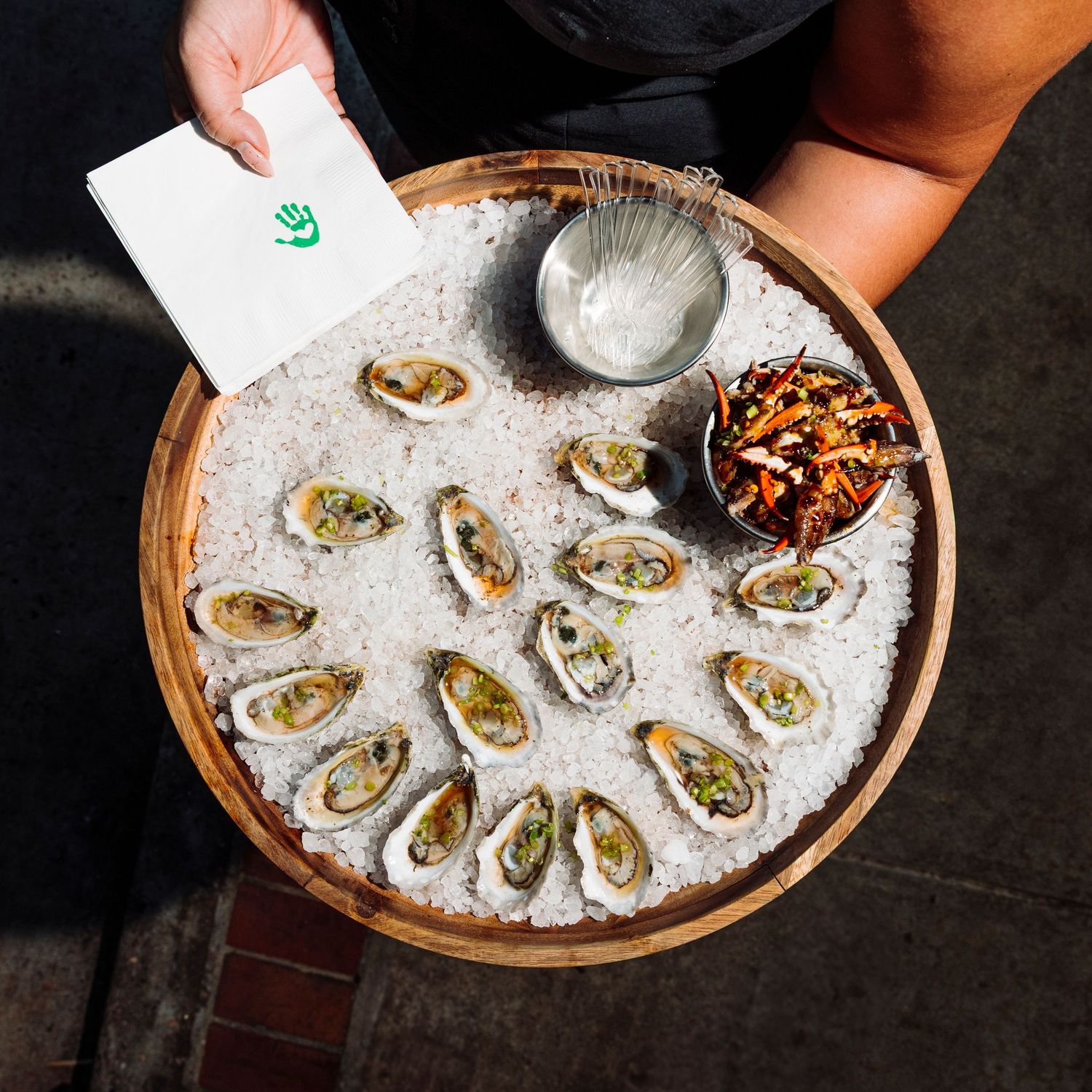 Fresh oysters on ice served in a round platter with seafood garnish.