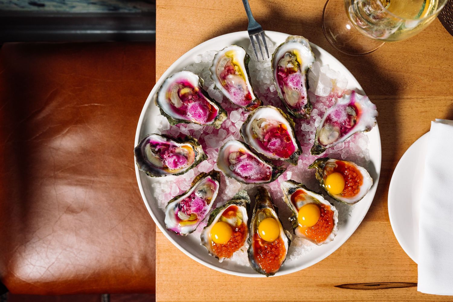 Vibrant oysters served on a plate at a luxury bar.