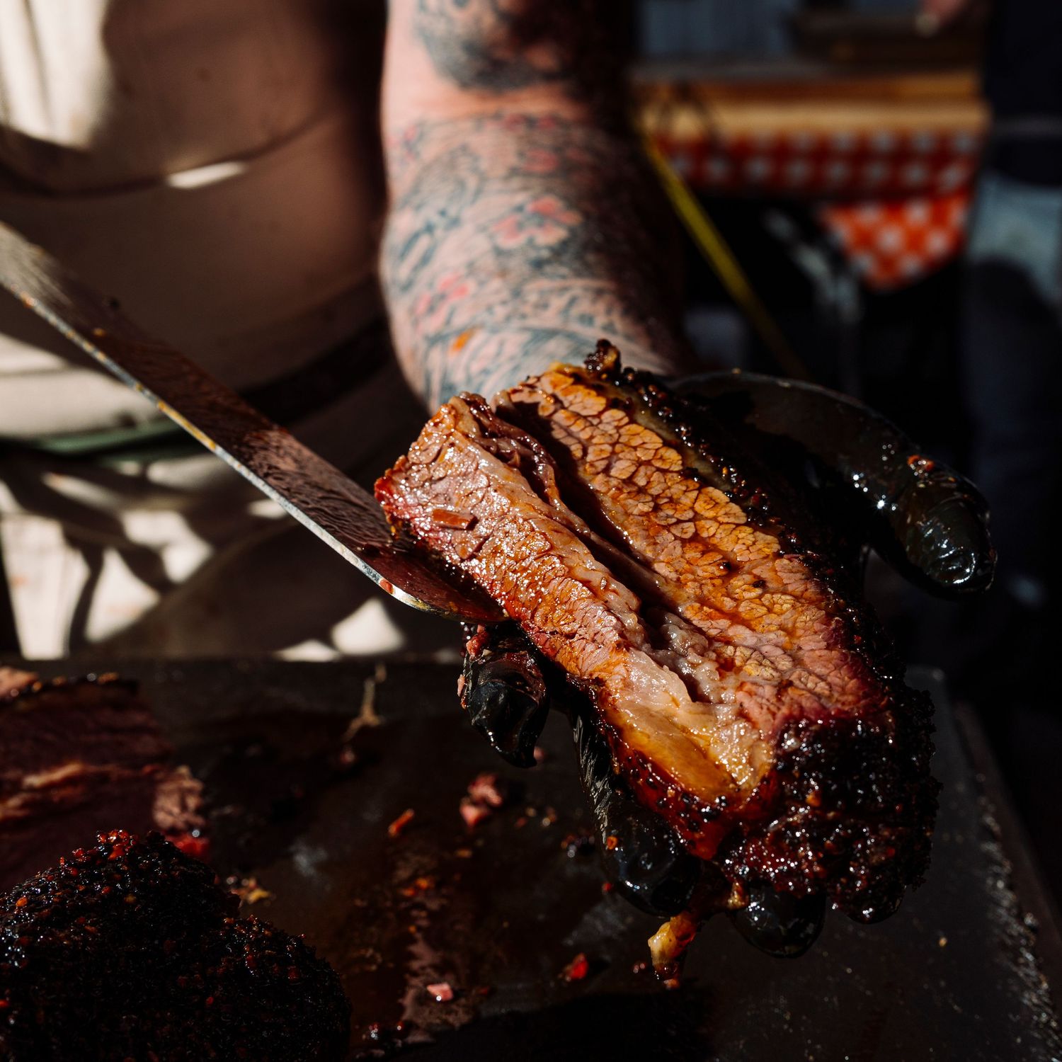 Perfectly smoked brisket being sliced to show pink smoke ring.