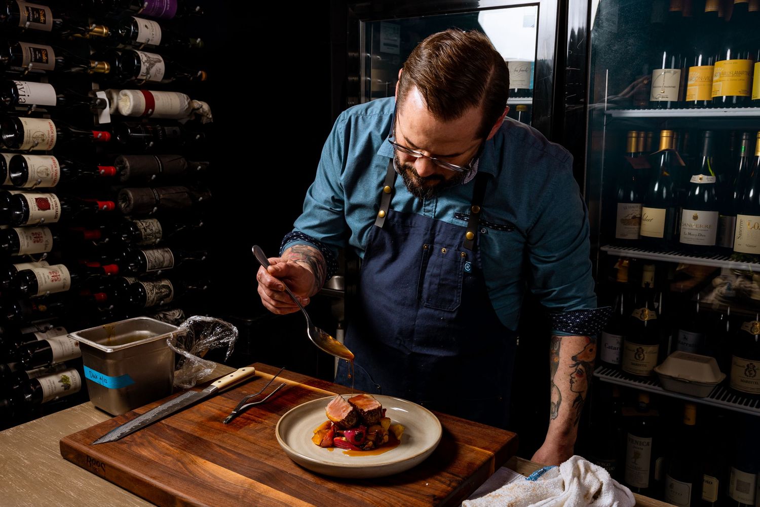 Restaurant staff plating and preparing elegant dishes in professional kitchen setting.