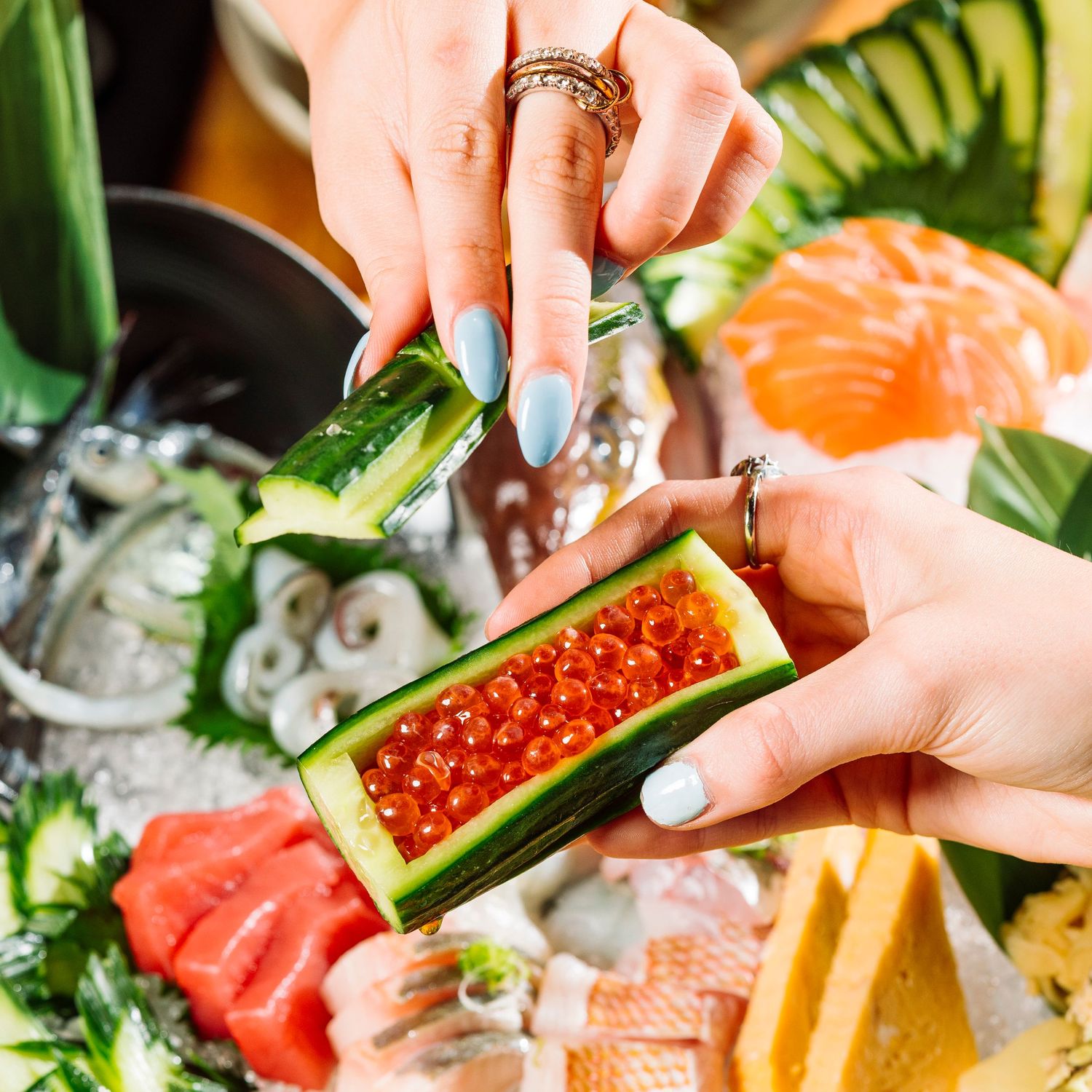 Fresh sushi and sashimi preparation with salmon roe and fresh fish.