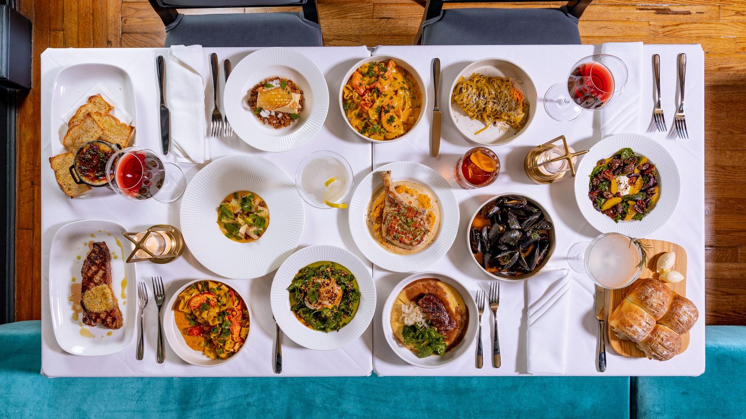 Overhead view of a restaurant table spread with various elegant dinner dishes and settings.