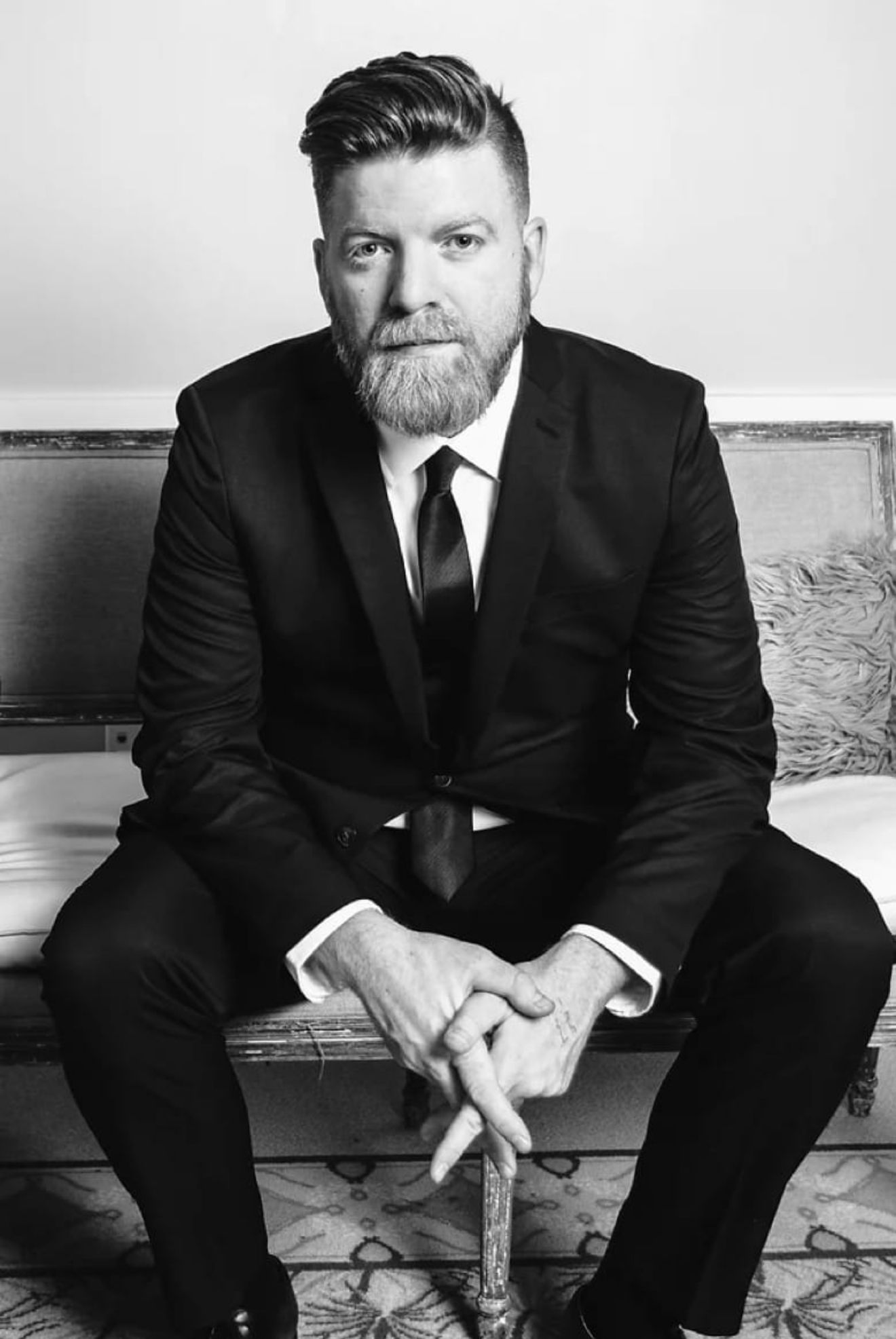 Black and white professional portrait in formal attire.