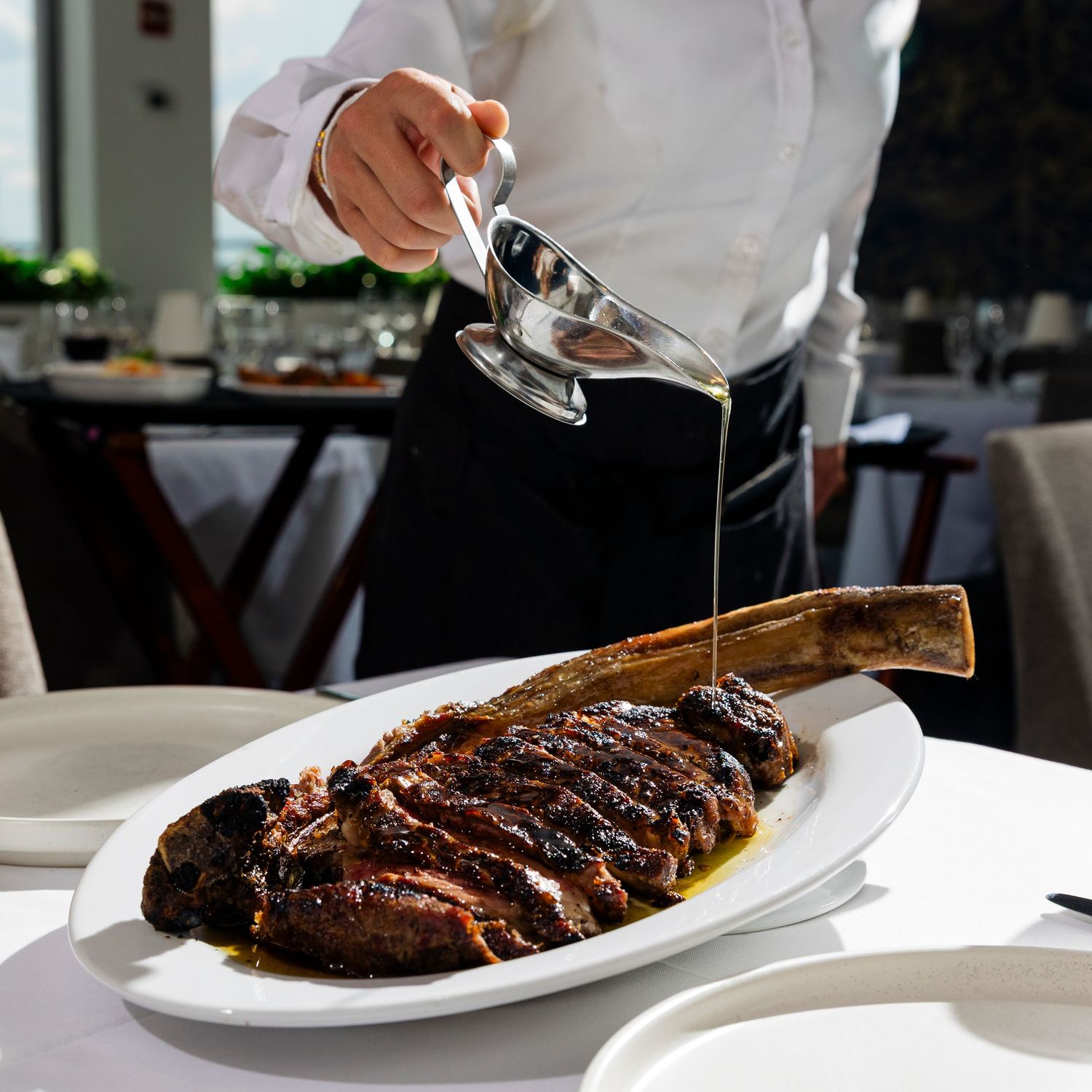 Chef plates a gourmet meat dish with precision and artful presentation.