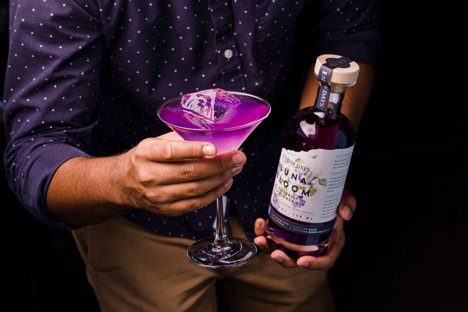 Purple-lit cocktail glasses and beverages in nightclub setting.