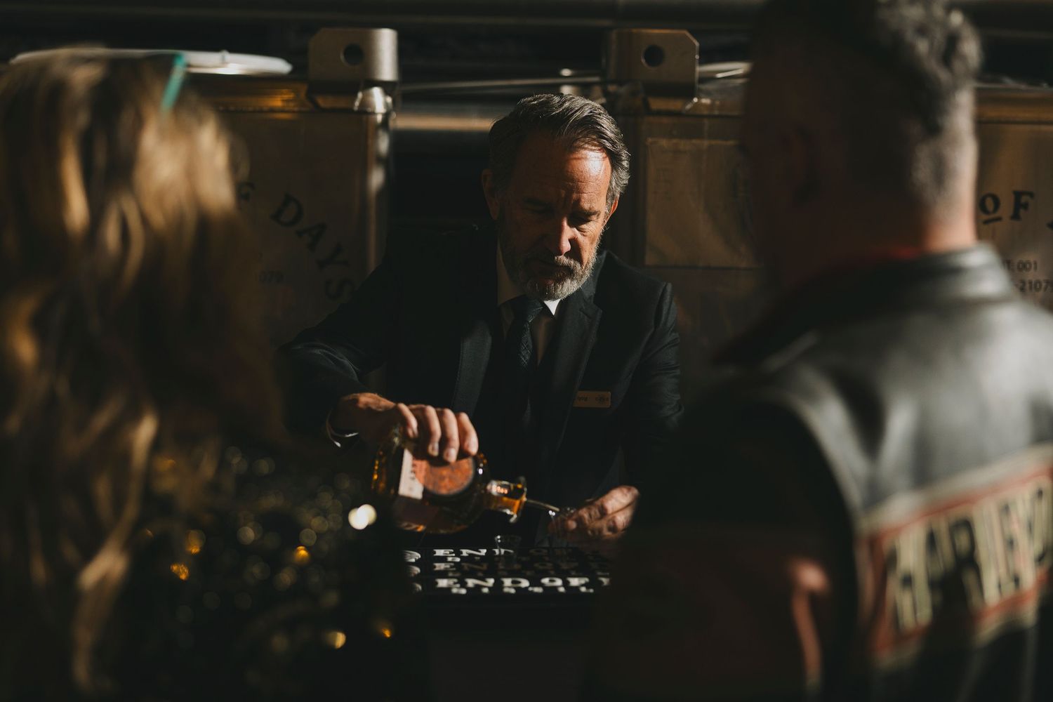 Sommelier examining wine in cellar with focused expression.
