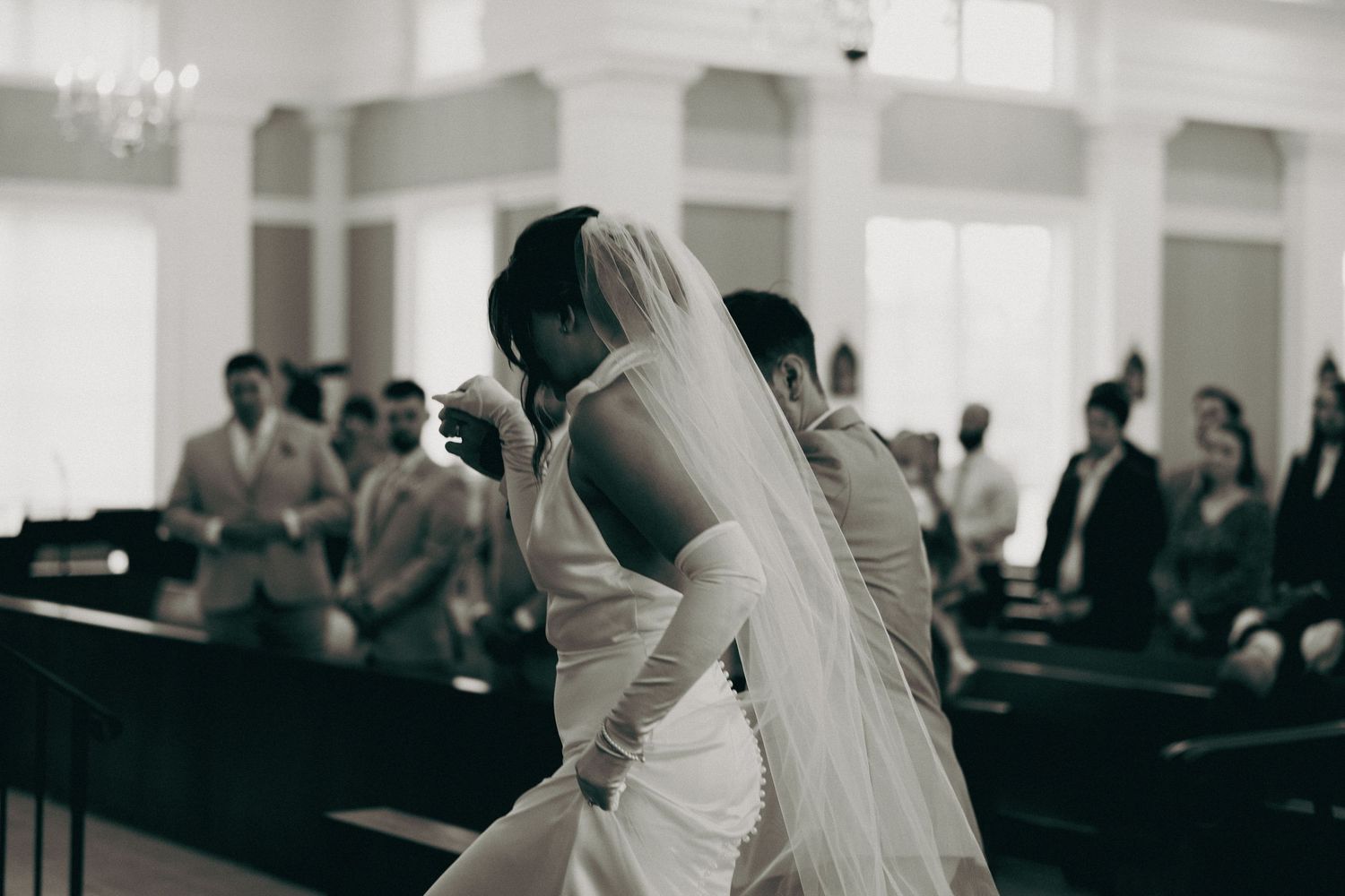 Wedding ceremony taking place in a bright, minimalist church interior.