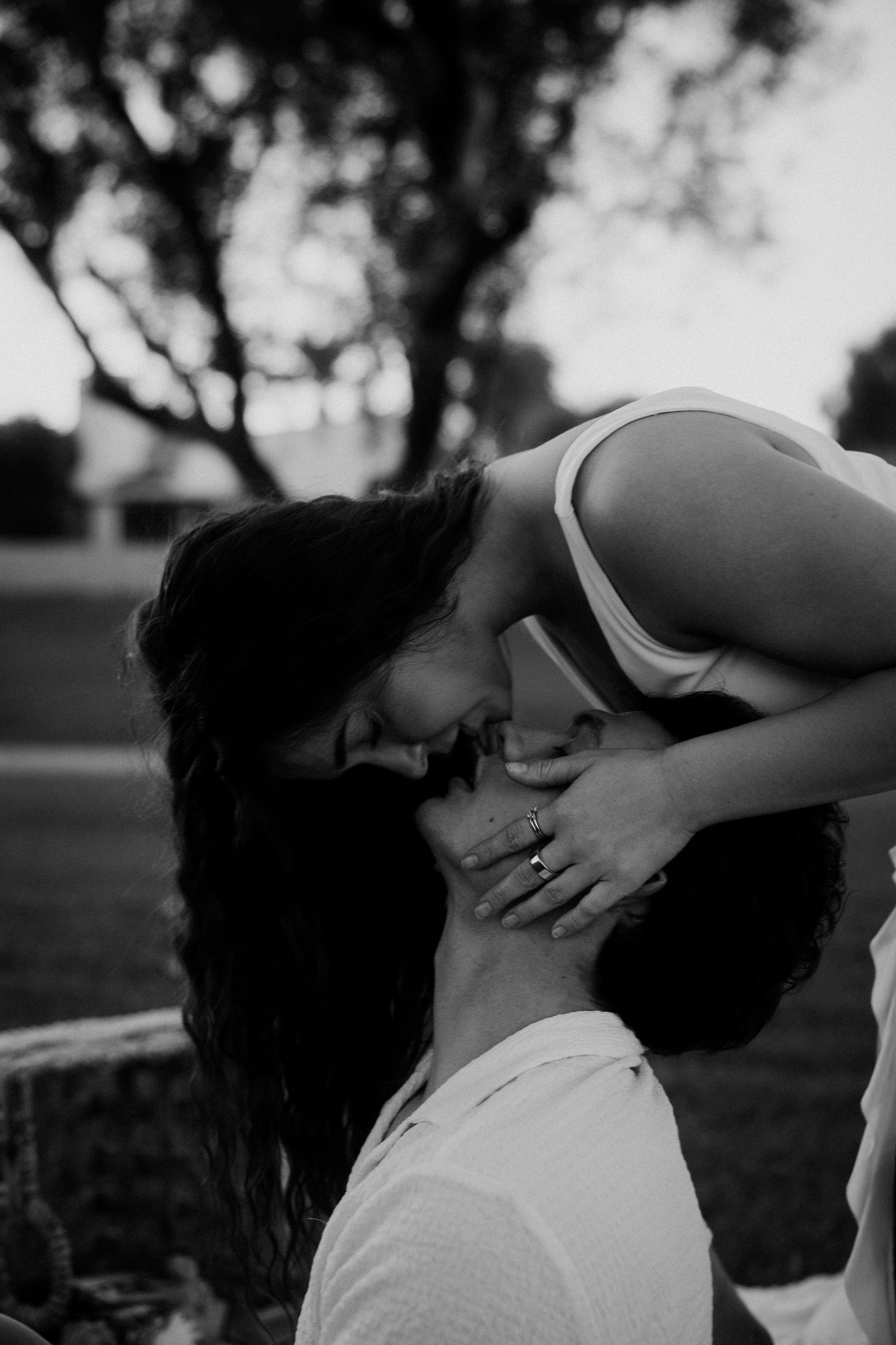 Romantic black and white portrait showing tender wedding moment outdoors.