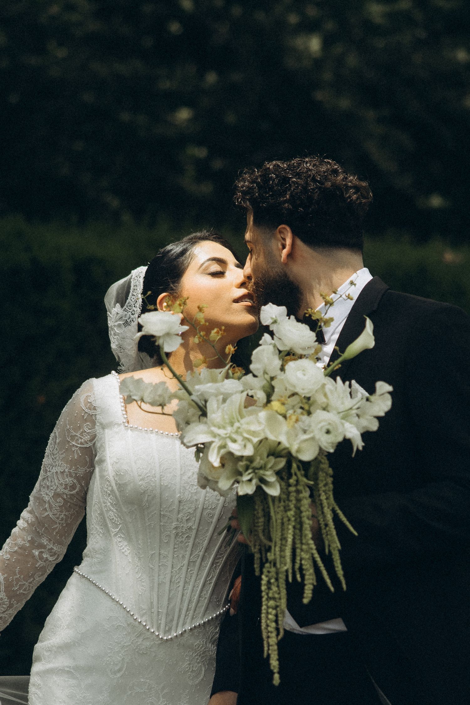Wedding couple with elegant white lily bouquet sharing an intimate moment.