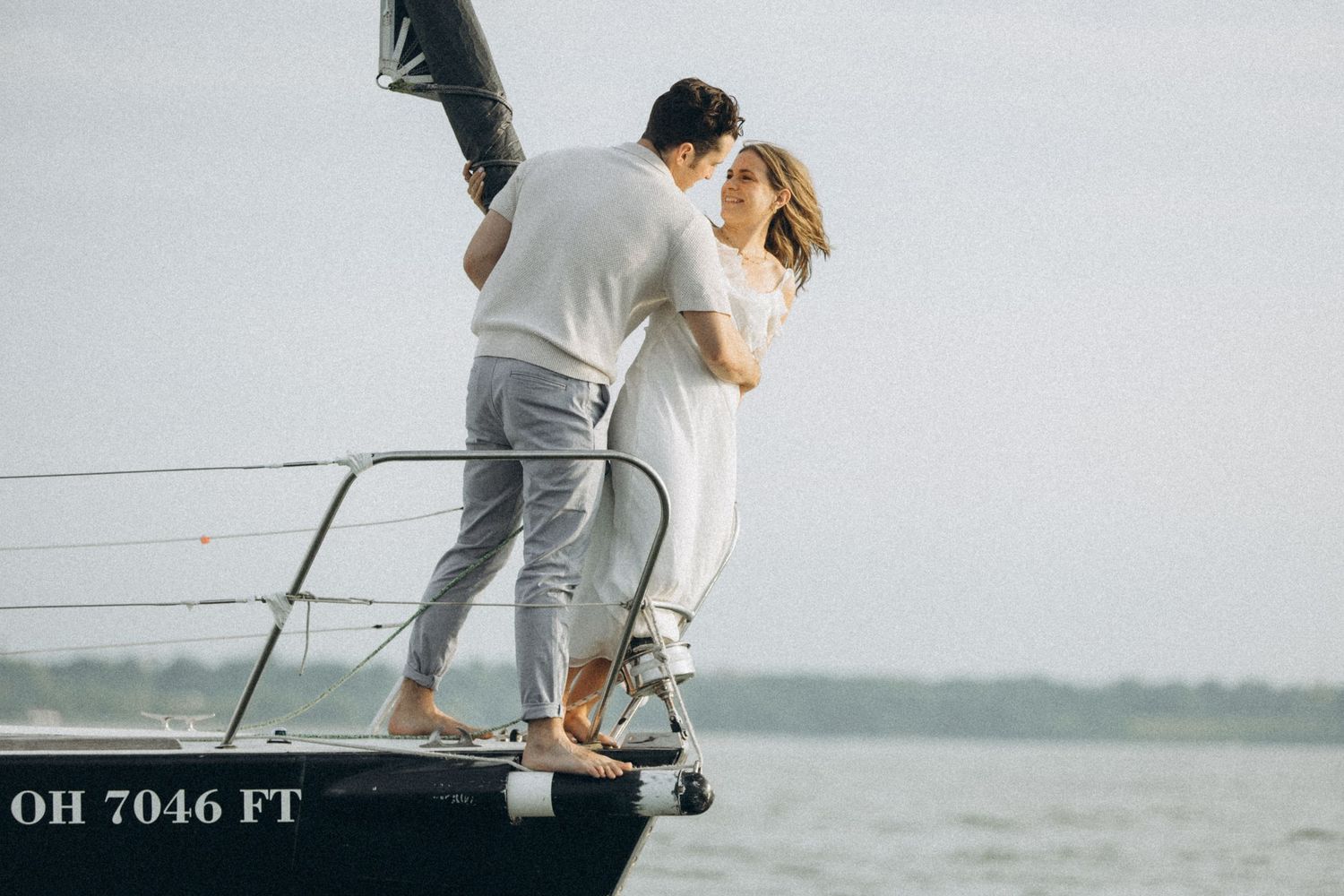 A couple enjoying a romantic moment on a sailboat at sea.