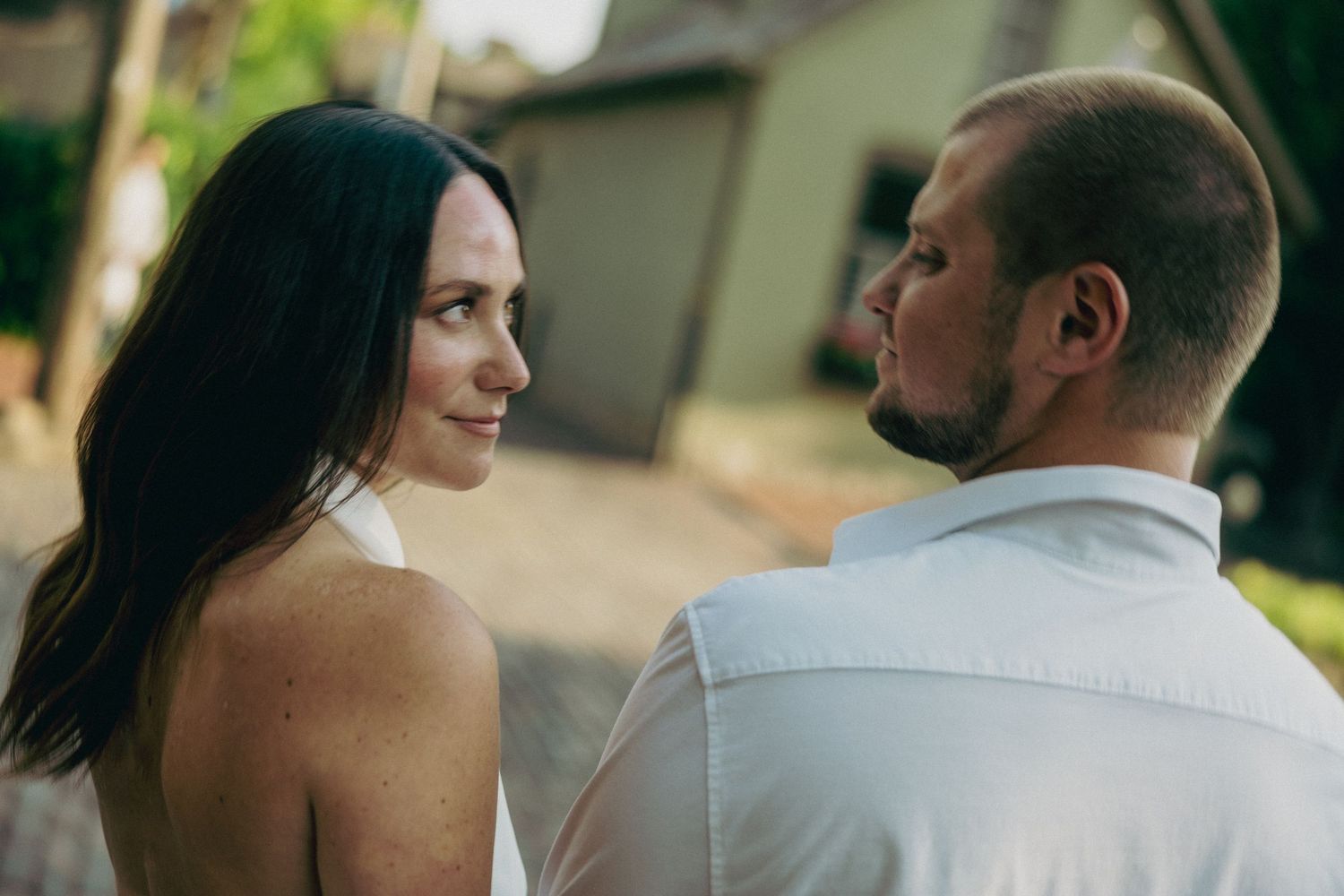 Couple sharing intimate moments on a garden path.