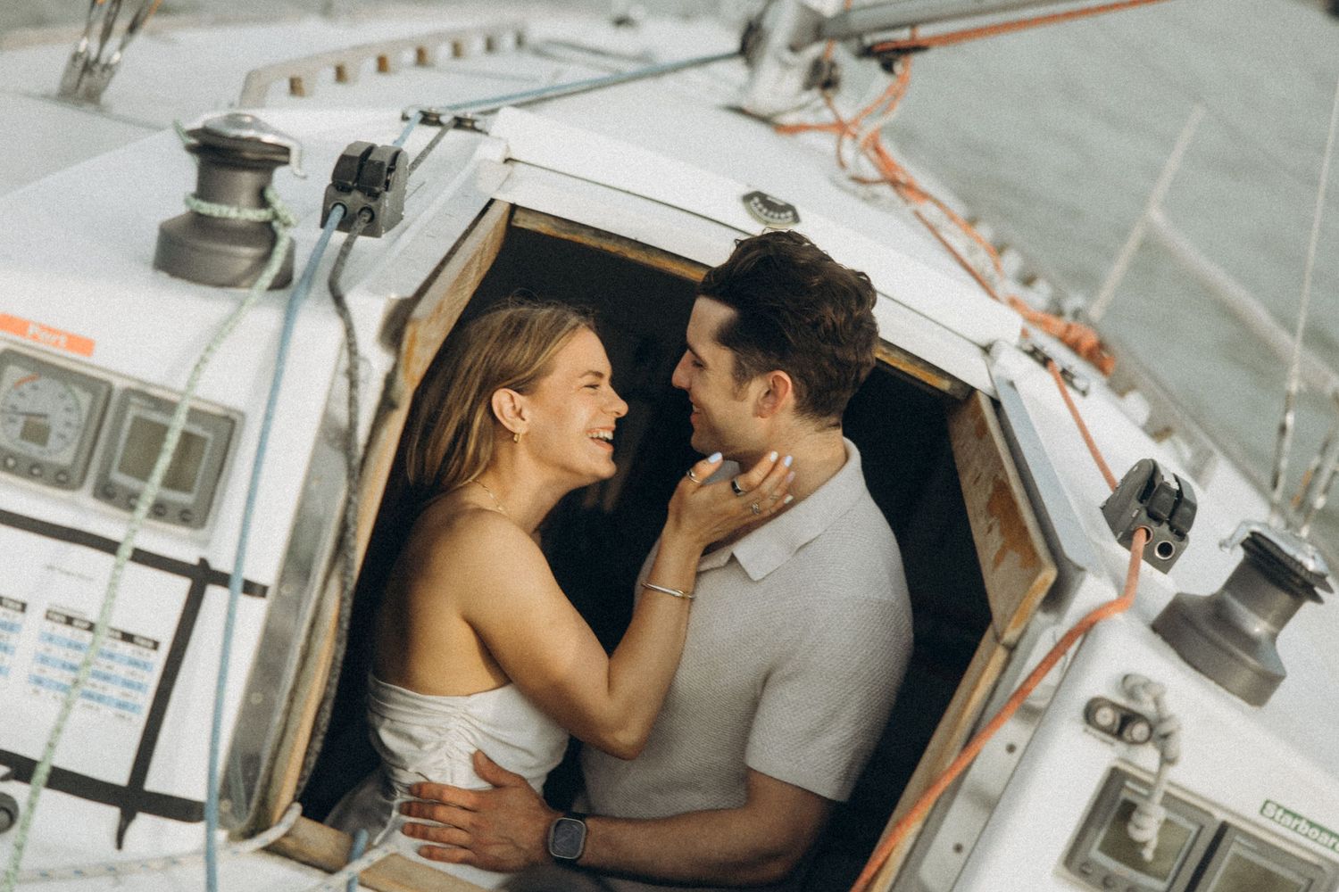 A romantic moment shared between a couple in a boat cabin.