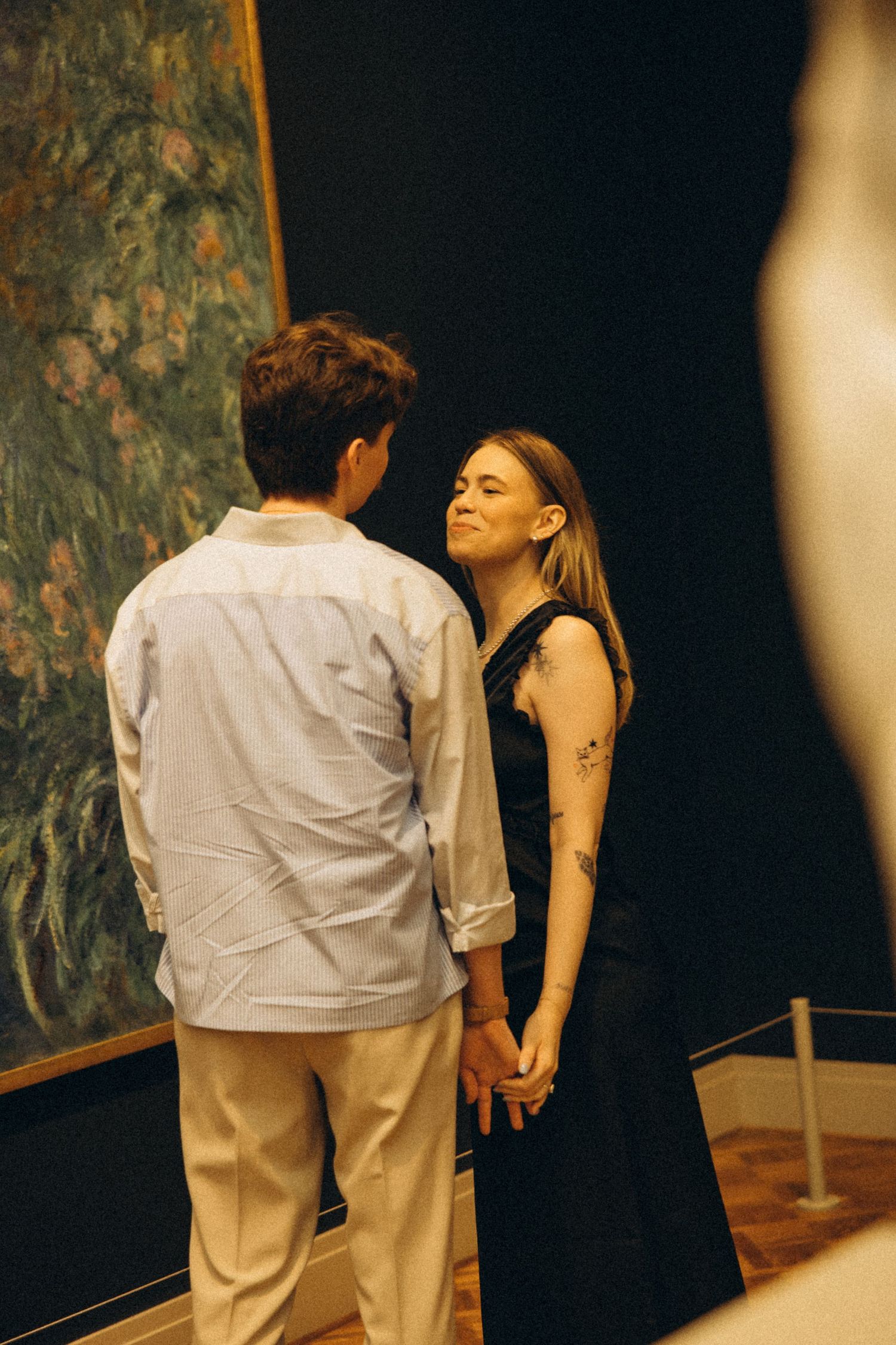 Two dancers performing an intimate dance sequence in a dimly lit space.