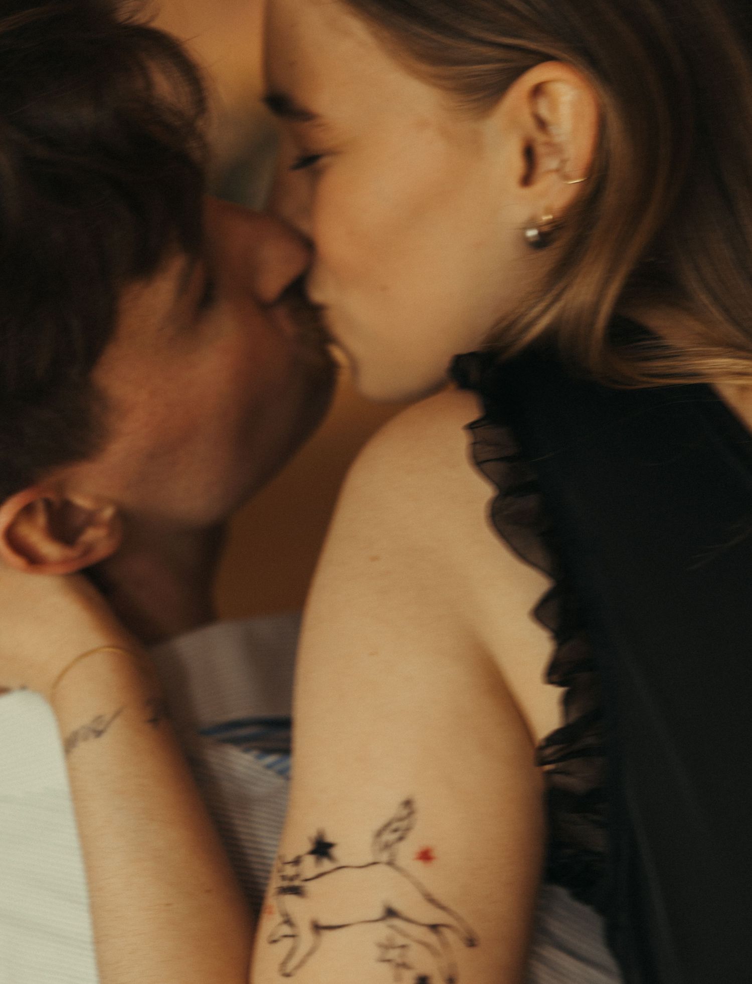 Intimate dance sequence showing movement and tattoo details in warm lighting.