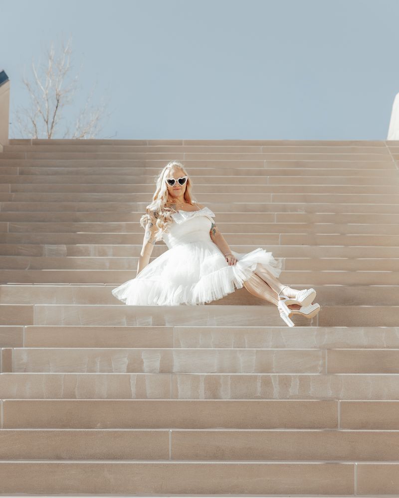 A sequence of photos showing a white dress flowing down concrete steps in an artistic motion.