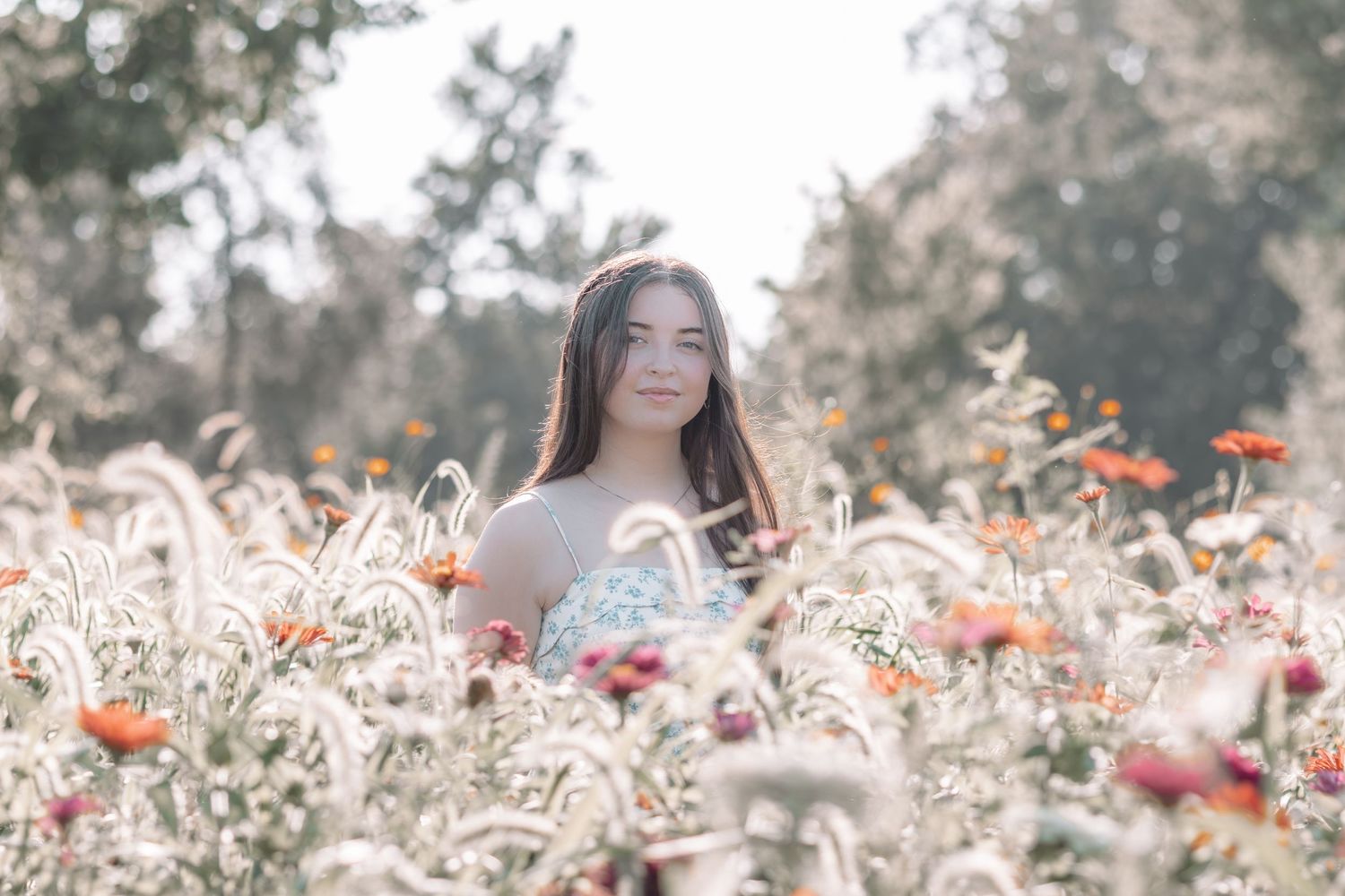 Ethereal outdoor portrait among white wildflowers and red poppies.