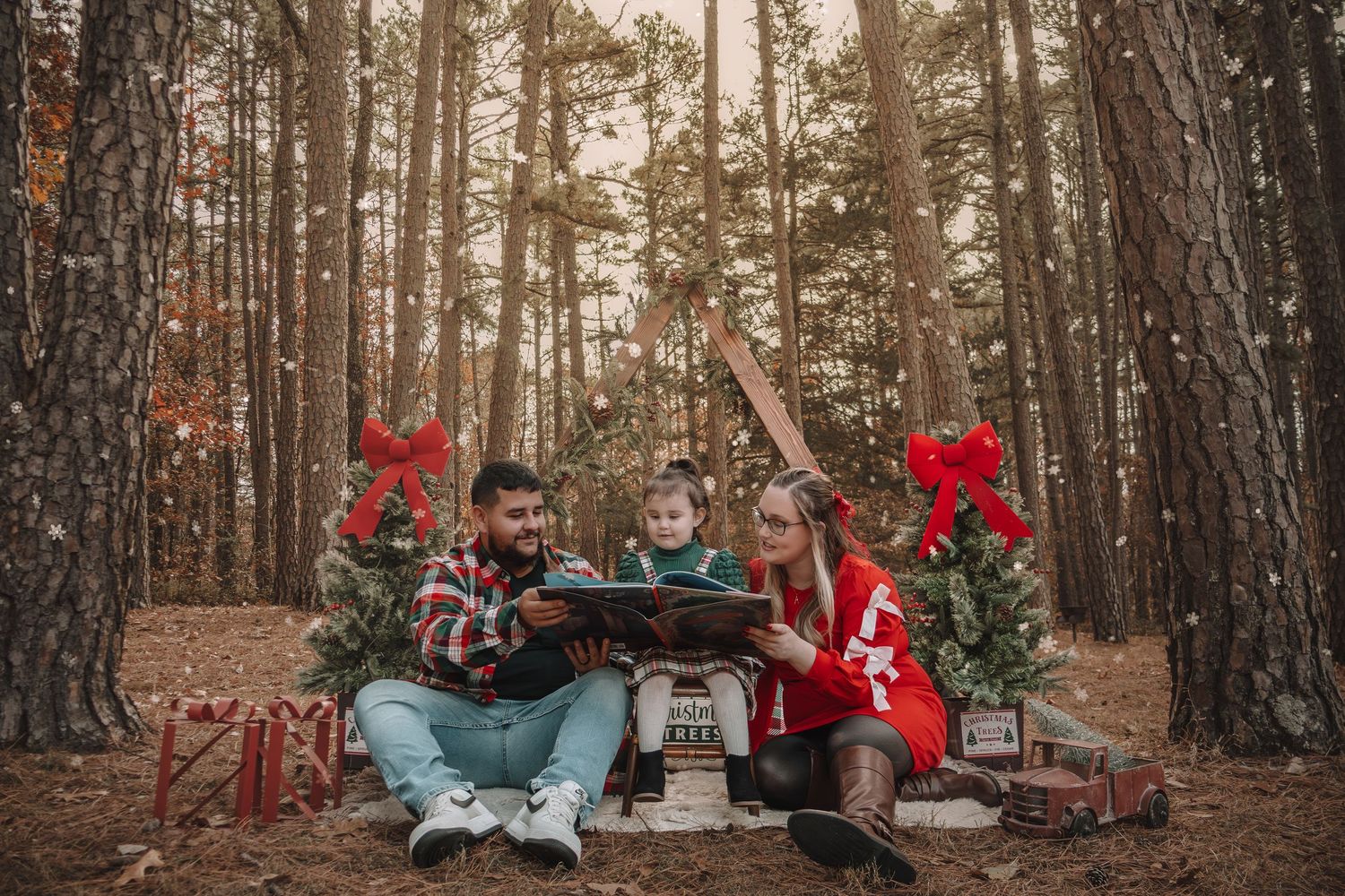 A romantic woodland picnic setup with red roses, cozy blankets, and decorative elements arranged between tall pine trees.