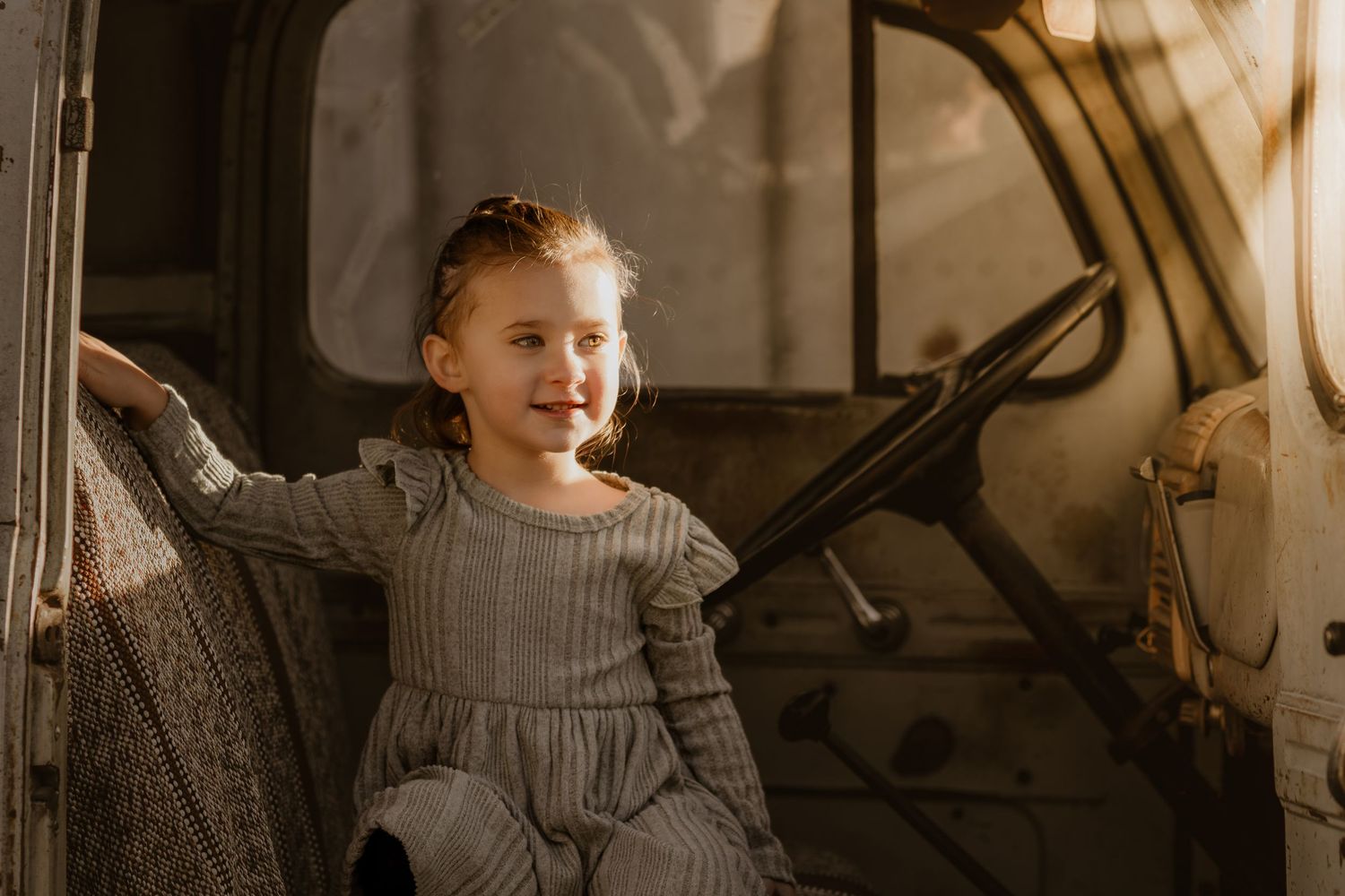 Candid family moment captured inside a rustic vehicle with natural lighting.